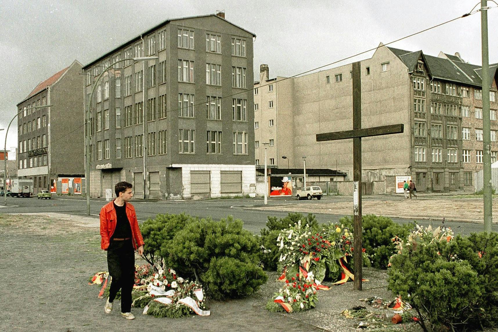 <strong>Ein Mann läuft an einem Gedenkkreuz <strong>zum Andenken an Peter Fechter vorbei.</strong></strong>