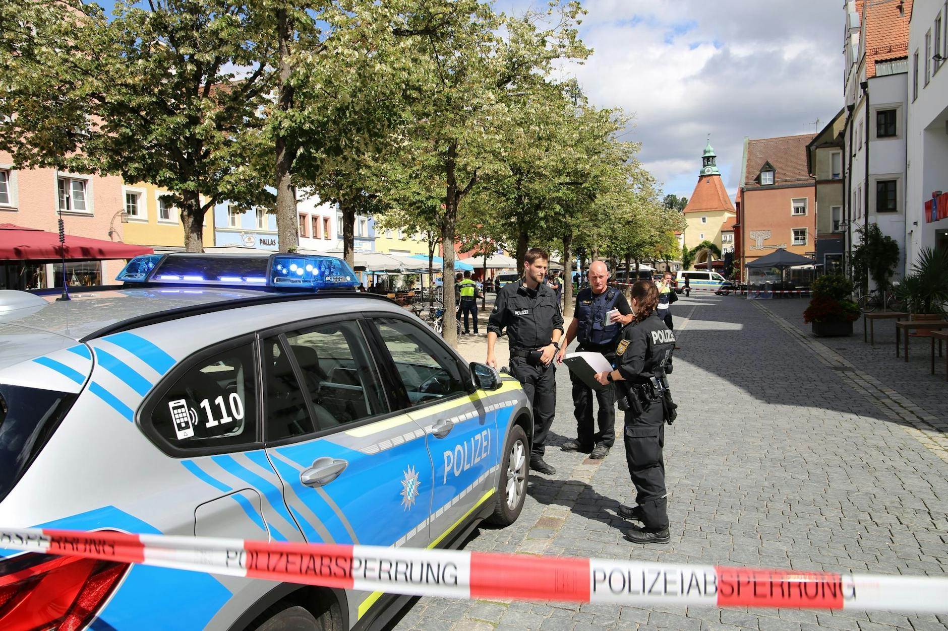 Polizeibeamte stehen bei dem Einsatz  in Weiden/Oberpfalz. Eine Frau hatte im Stadtzentrum mehrere Menschen verletzt.  