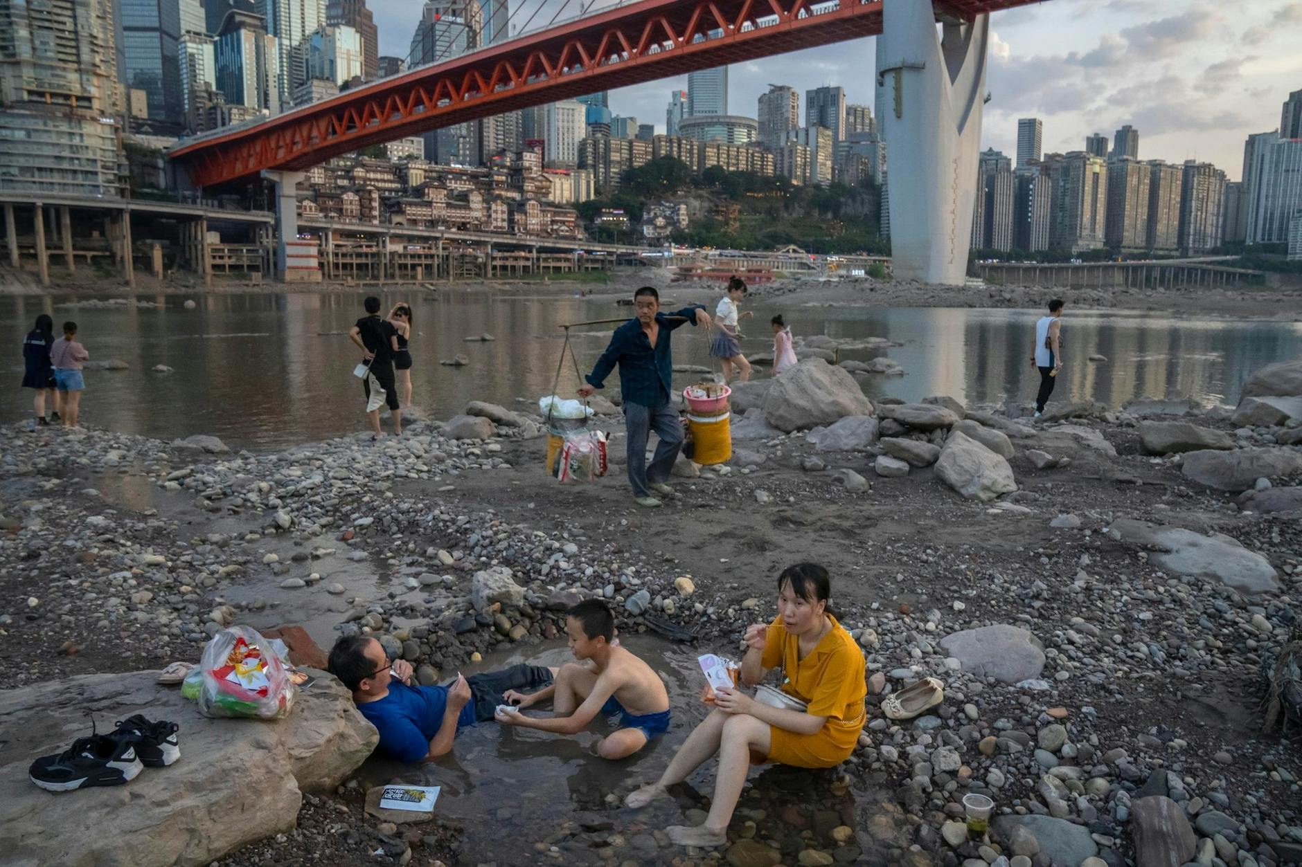 dpatopbilder - China kämpft gegen die Dürre. Menschen sitzen in einem flachen Wasserbecken im Flussbett des Jialing-Flusses, einem Nebenfluss des Jangtse, in der südwestchinesischen Stadt Chongqing.