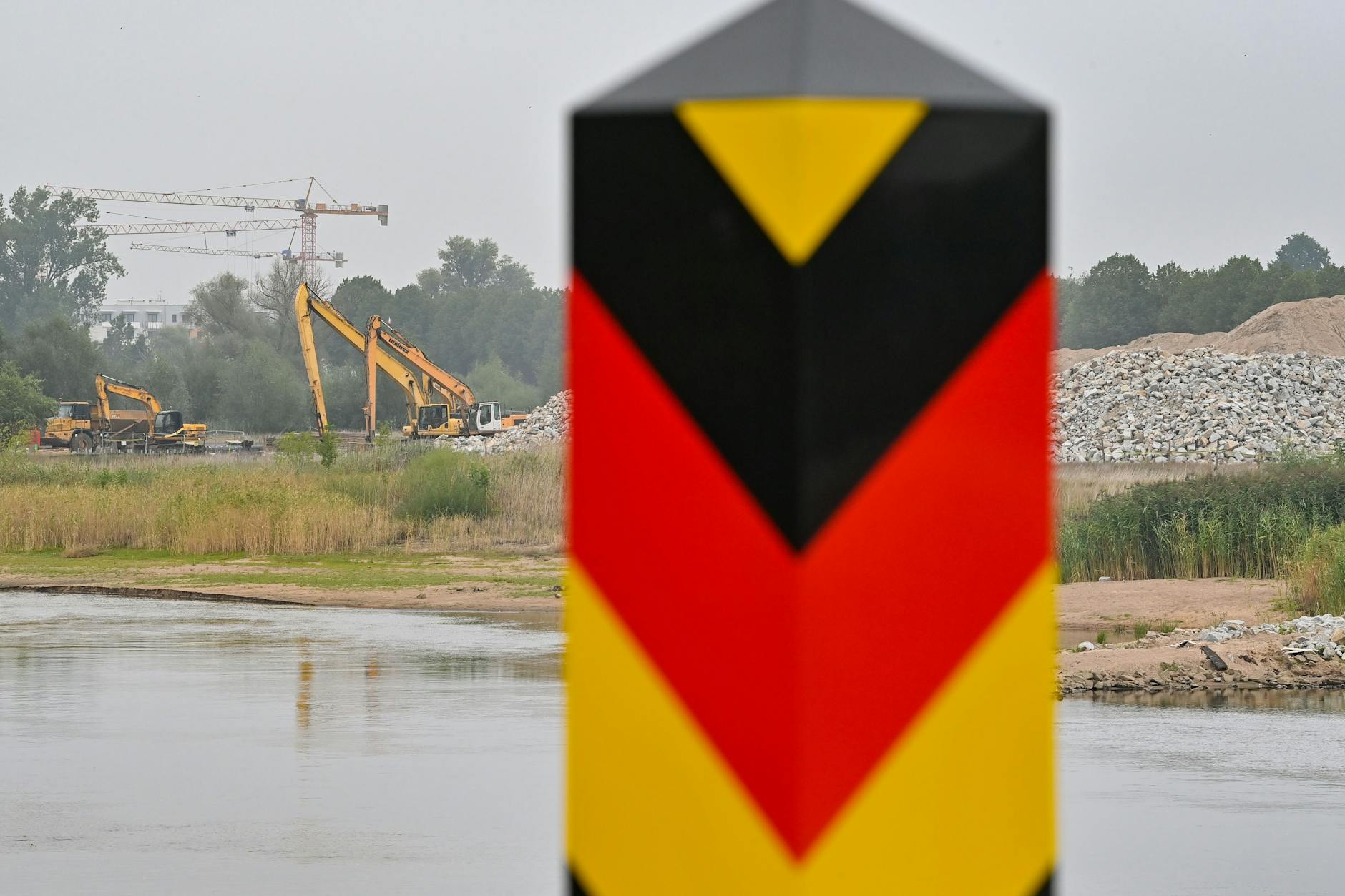 Baumaschinen zum Ausbau des deutsch-polnischen Grenzflusses Oder stehen auf der polnischen Uferseite. 