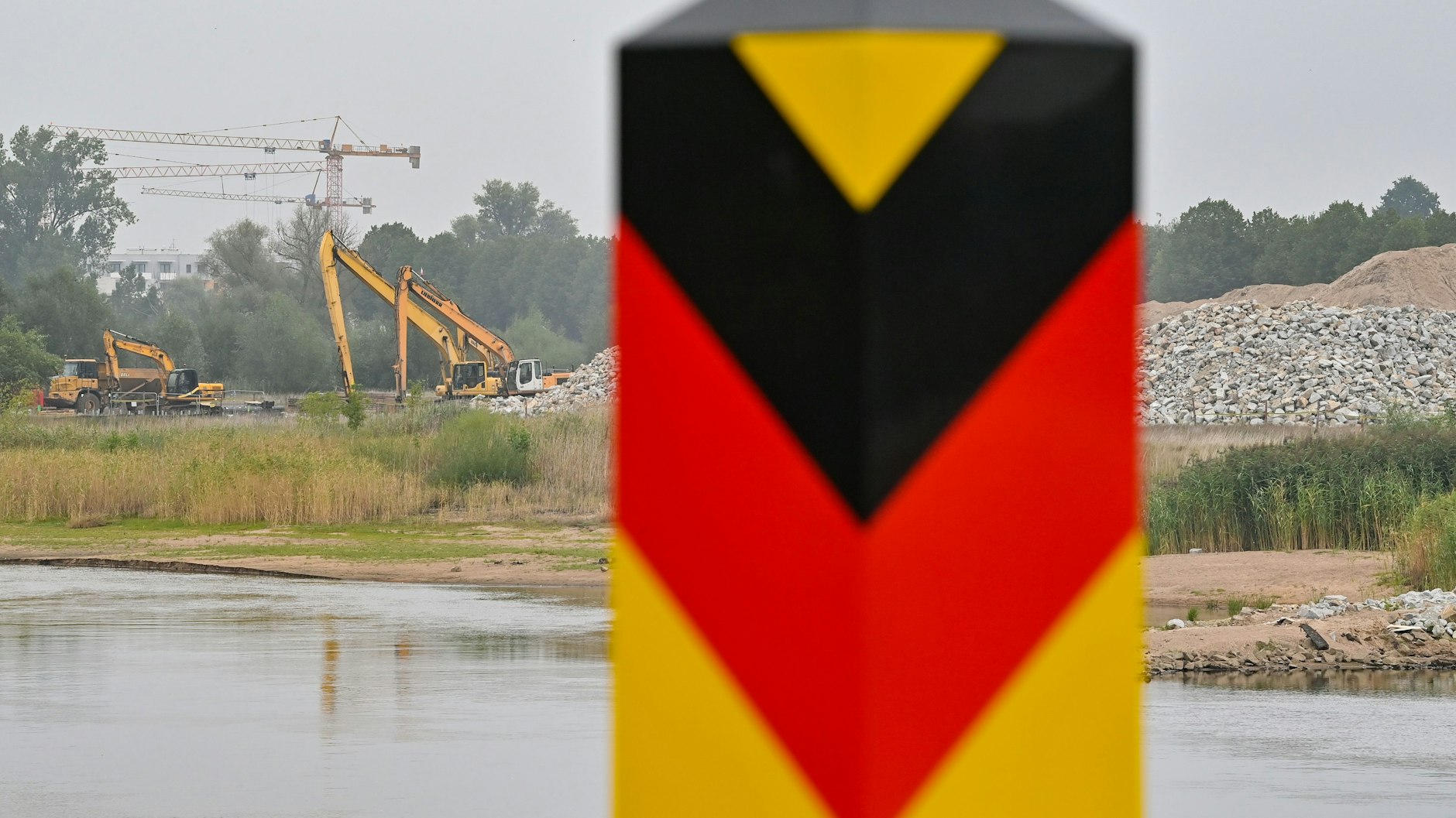 Bei Frankfurt / Oder stehen Baumaschinen zum Ausbau des deutsch-polnischen Grenzflusses auf der polnischen Uferseite. 