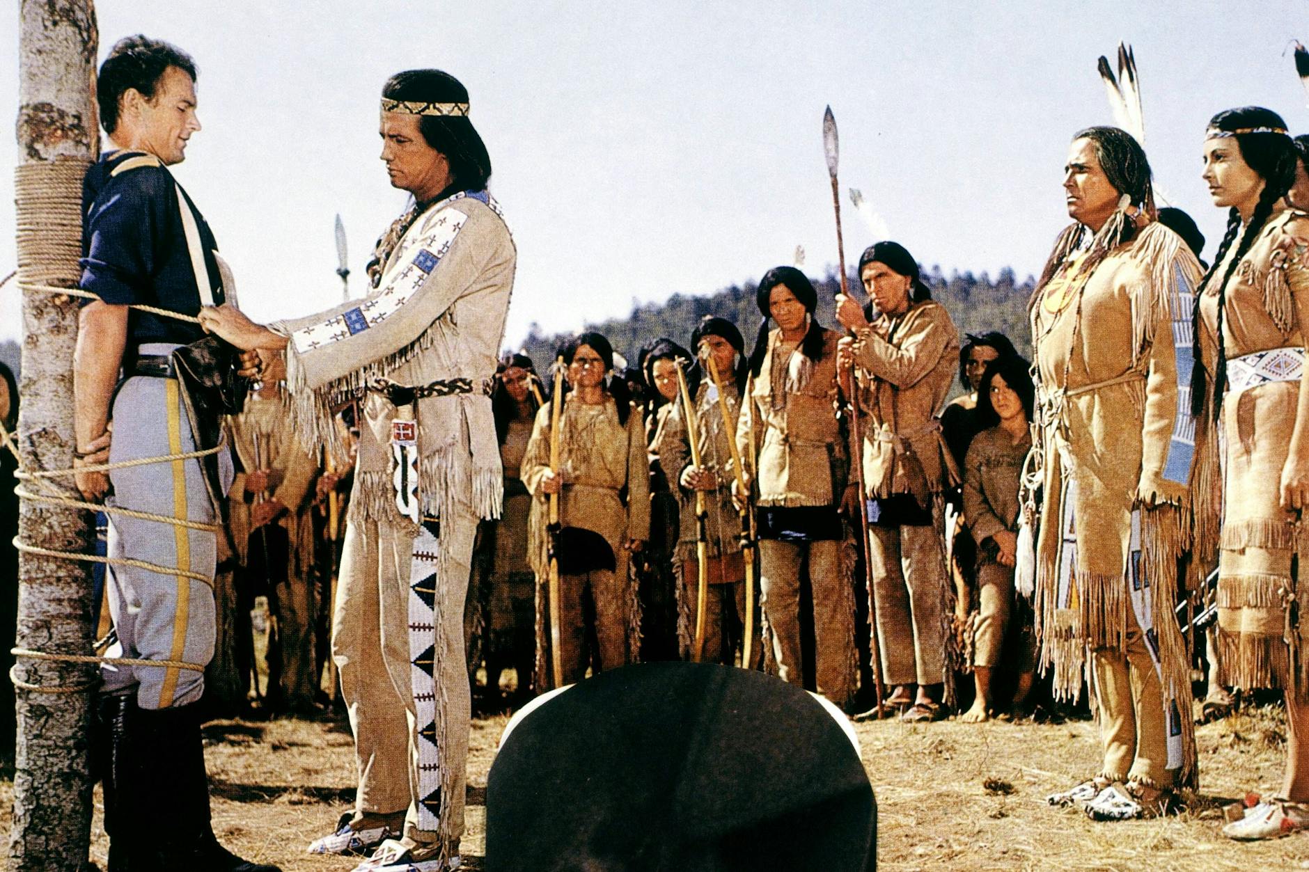 Klischees bei „Winnetou II“, die Millionen Zuschauer geprägt haben: Terence Hill als Lieutenant Robert Merril an einem „Marterpfahl“, Pierre Brice als Winnetou.