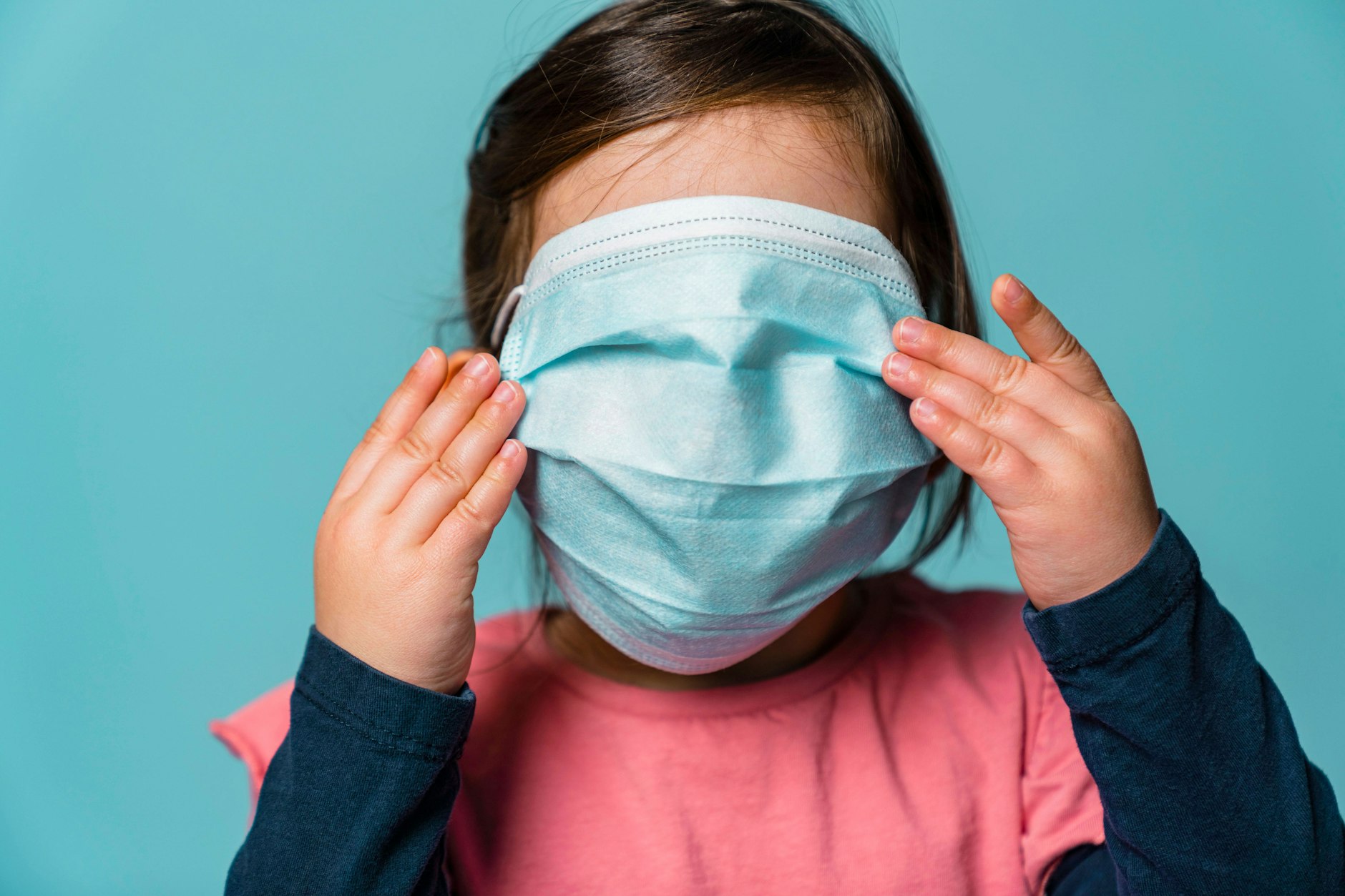 Ein Kind trägt eine Maske über dem Gesicht.