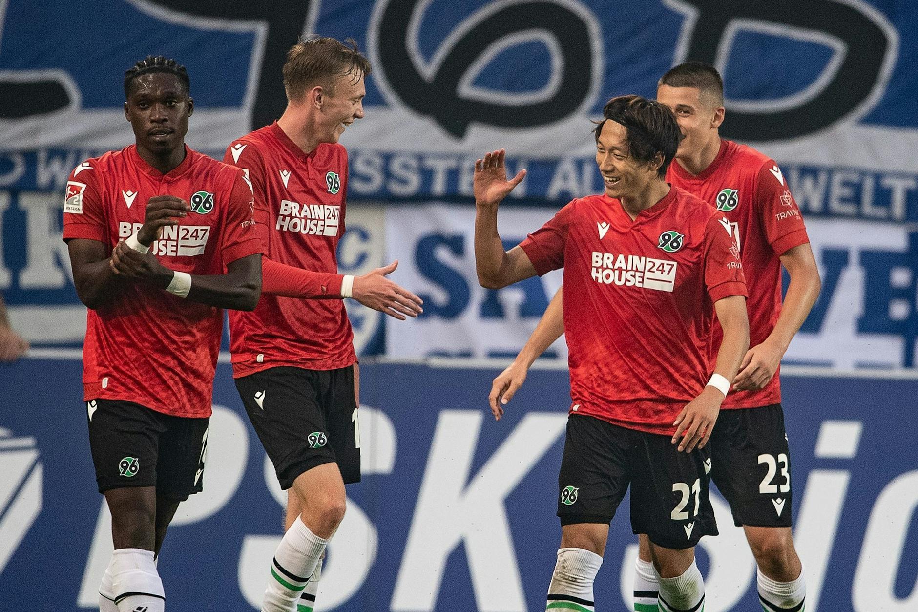 Hannovers Sei Muroya (2.v.r.) klatscht mit Maximilian Beier nach seinem Tor zum 3:0 beim FC Magdeburg ab. - Nutzung nur nach schriftlicher Vereinbarung mit der dpa