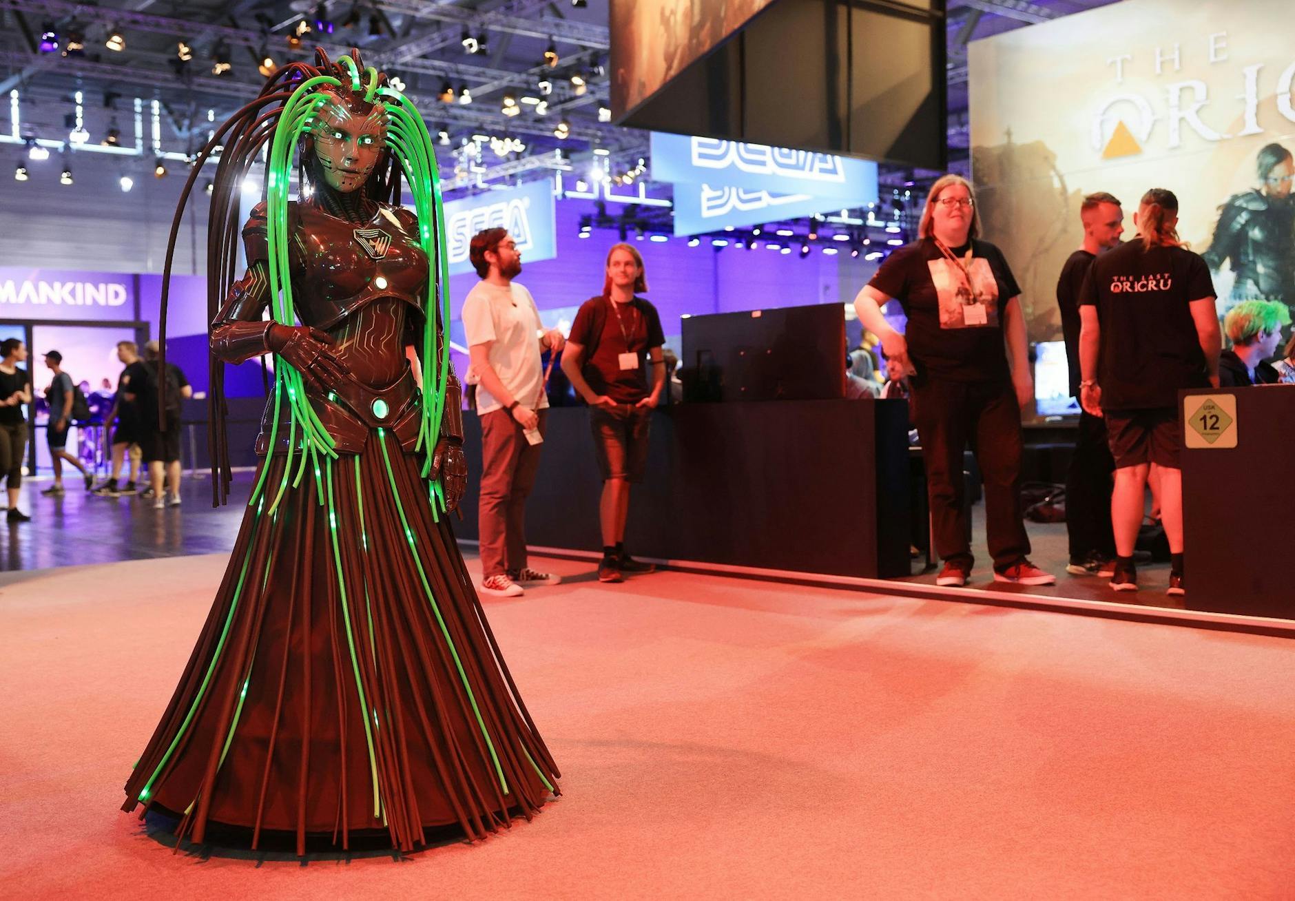 Eine Figur aus einem Computerspiel geht durch die Messehalle in Köln. Nach zwei Ausgaben ohne Publikum findet die Videospielmesse Gamescom wieder mit Besuchern statt.
