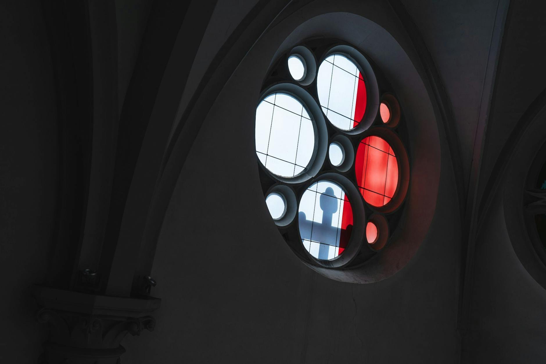 ARCHIV - Bei einer Solidaritätsaktion mit den Missbrauchsopfern der katholischen Kirche wirft das Licht den Schatten eines Kreuzes durch eines der Fenster der Kirche Maria Geburt (Symbolbild).