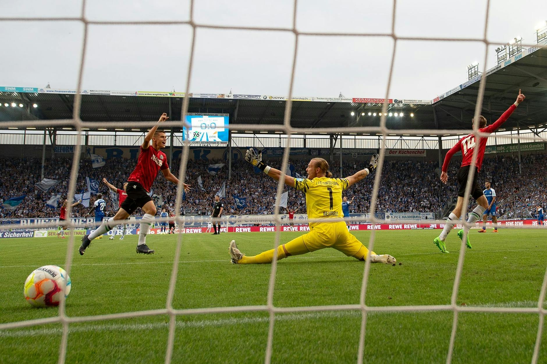 Maximilian Beier (r) jubelt mit Nicolo Tresoldi nach seinem Tor zum 1:0 für Hannover: Magdeburgs Torwart Dominik Reimann (M) ist überwunden. - Nutzung nur nach schriftlicher Vereinbarung mit der dpa