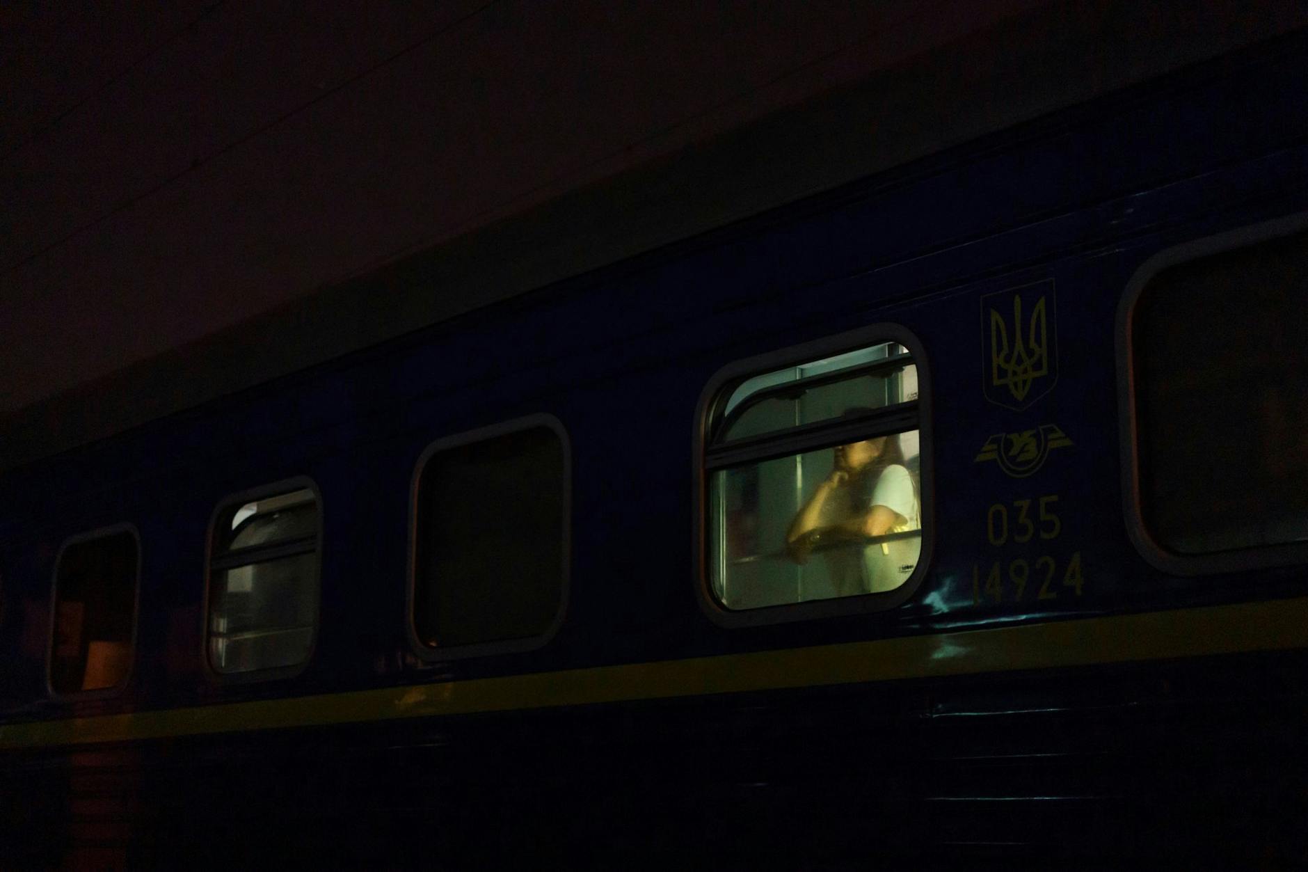 Eine Fahrgästin schaut am Bahnhof in Kiew aus dem Fenster eines Nachtzuges Richtung Lwiw.