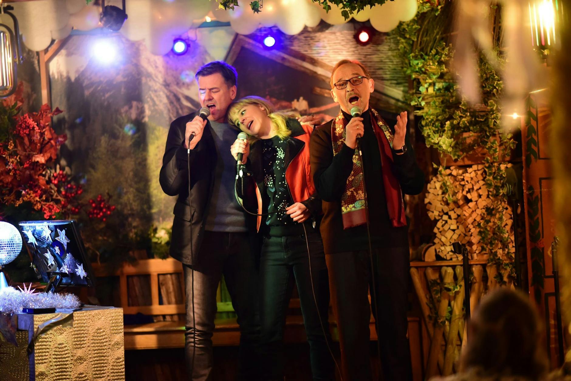 HANDOUT - Die Kommissare Harald Neuhauser (Marcus Mittermeier, l), Angelika Flierl (Bernadette Heerwagen, M) und Ludwig Schaller (Alexander Held, r) singen Karaoke.