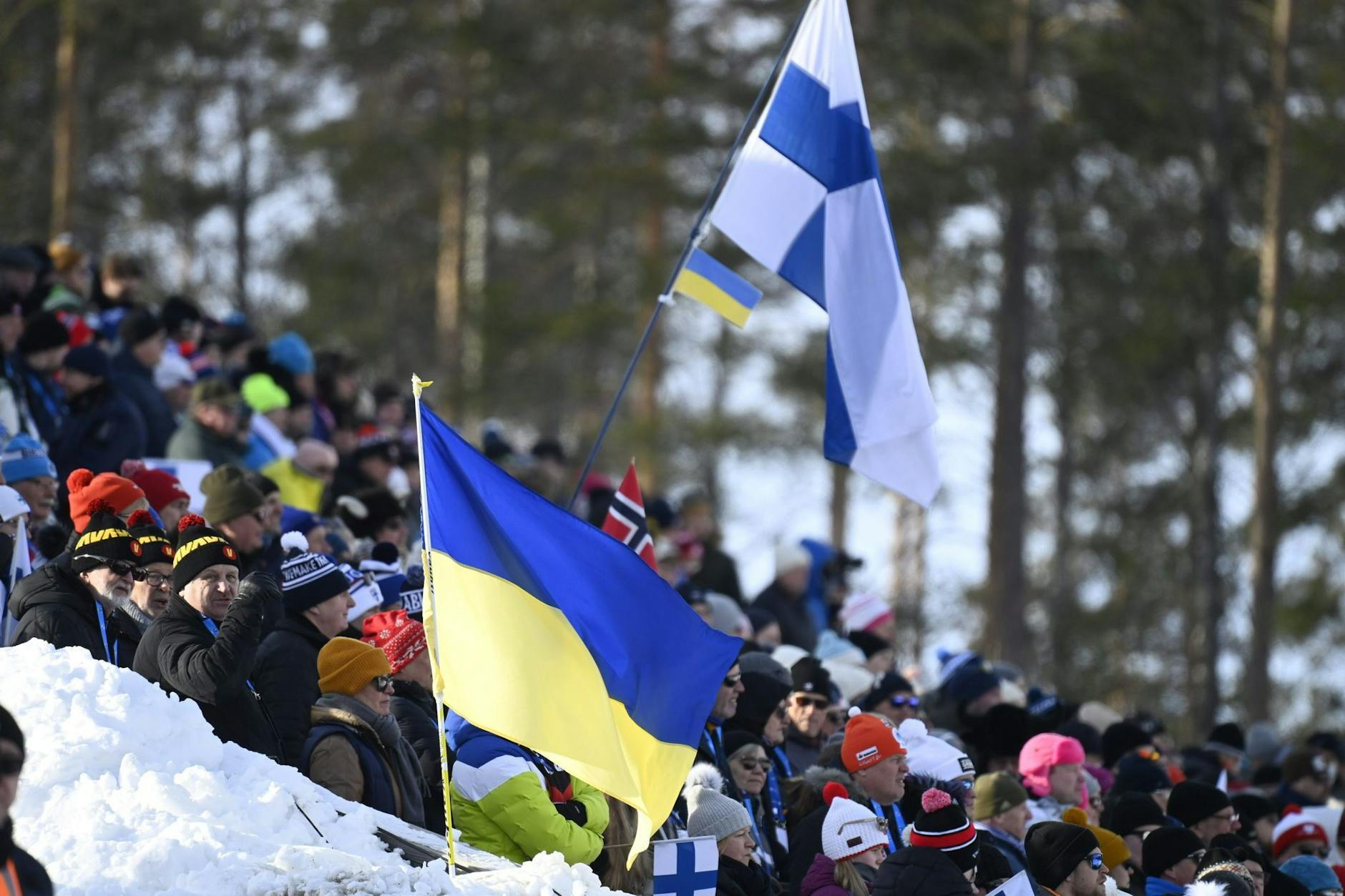 ARCHIV - Die ukrainische Fahne weht neben der finnischen Fahne während eines Biathlon-Weltcups.