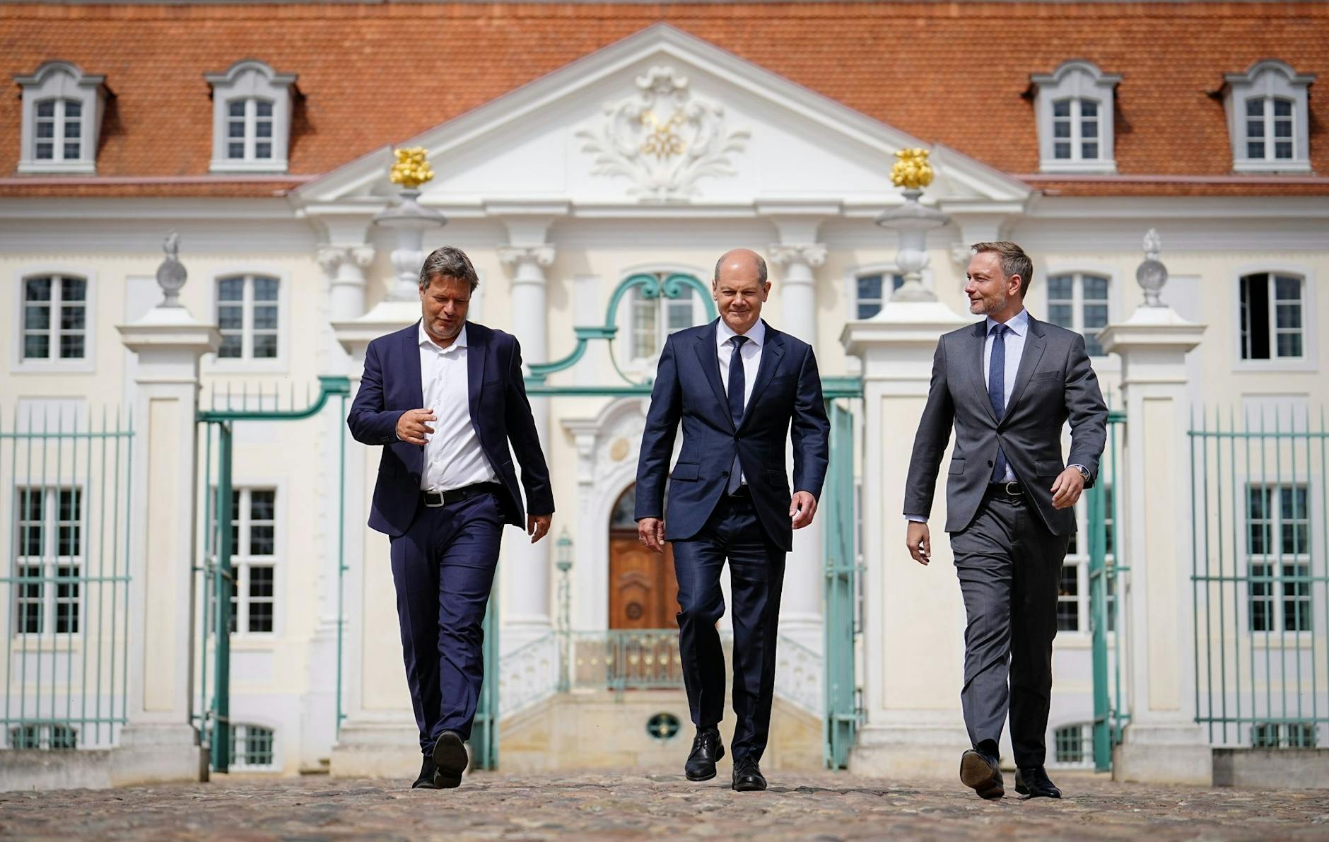 ARCHIV - Kanzler Olaf Scholz (M), Wirtschaftsminister Robert Habeck (l) und Finanzminister Christian Lindner vor dem Schloss Meseberg.