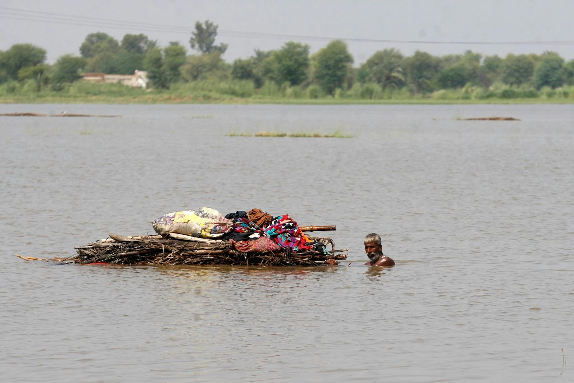 Ein Mann transportiert brauchbare Habseligkeiten aus seinem von der Flut zerstörten Haus in Shikarpur in Südostpakistan.
