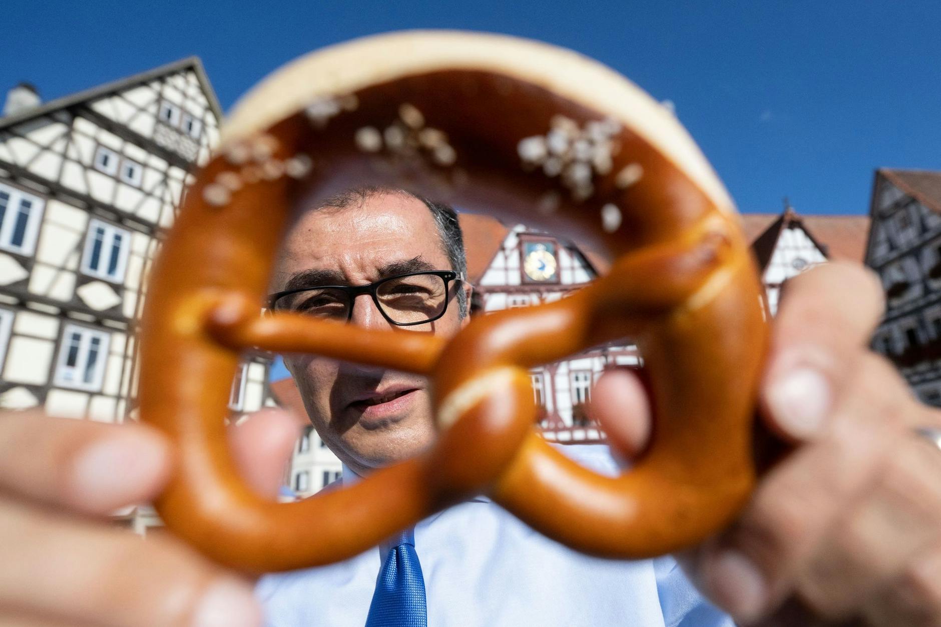 Schmeckt! Cem Özdemir (Bündnis 90/Die Grünen) lugt hinter einer Brezel hervor.