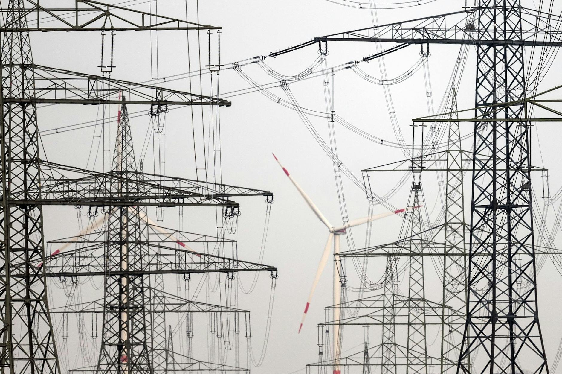 ARCHIV - Strommasten stehen in der Nähe eines Windparks. d