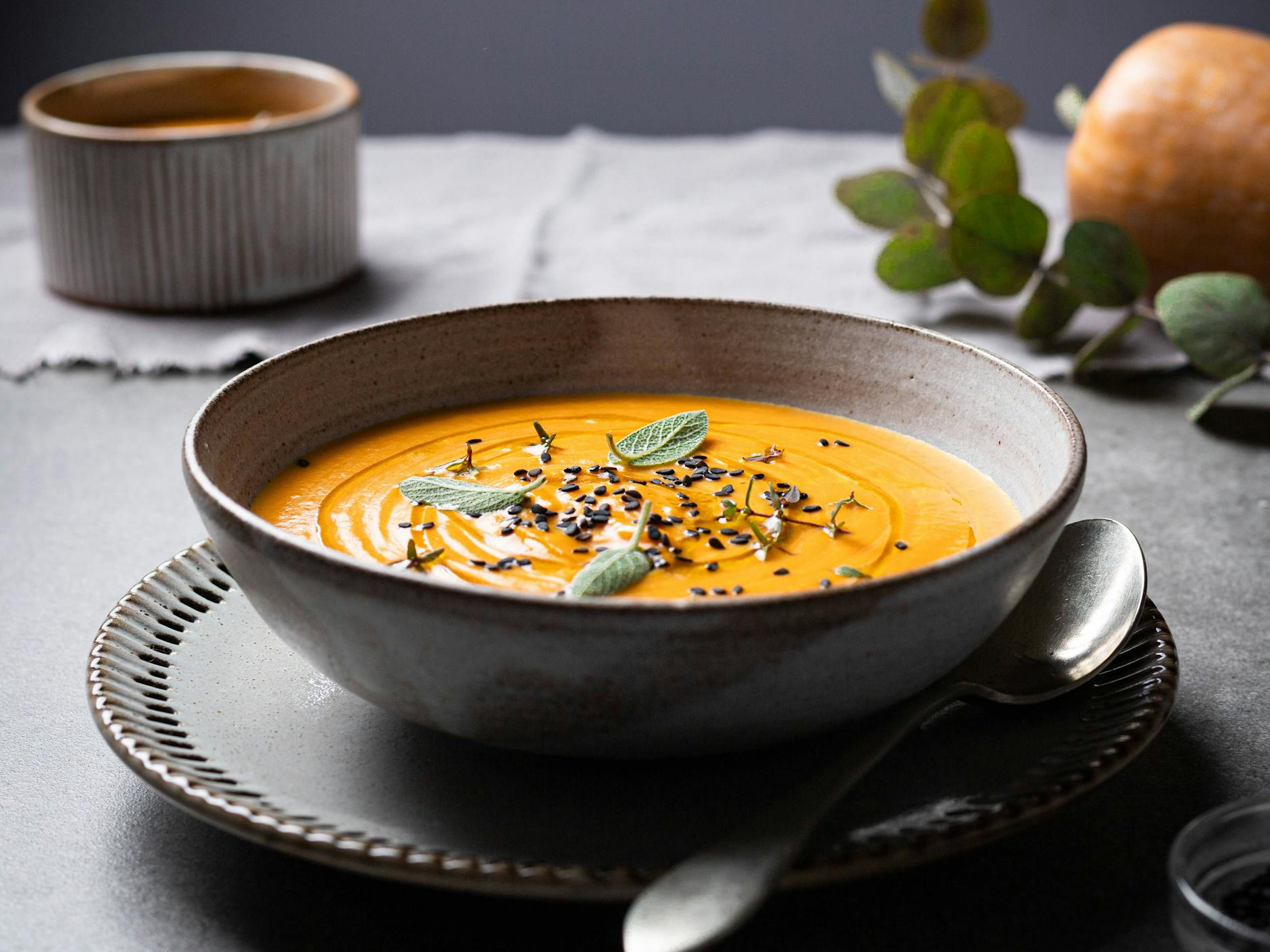 Ein paar Kräuter und eine Handvoll Chiasamen dekorieren die Kürbissuppe perfekt.
