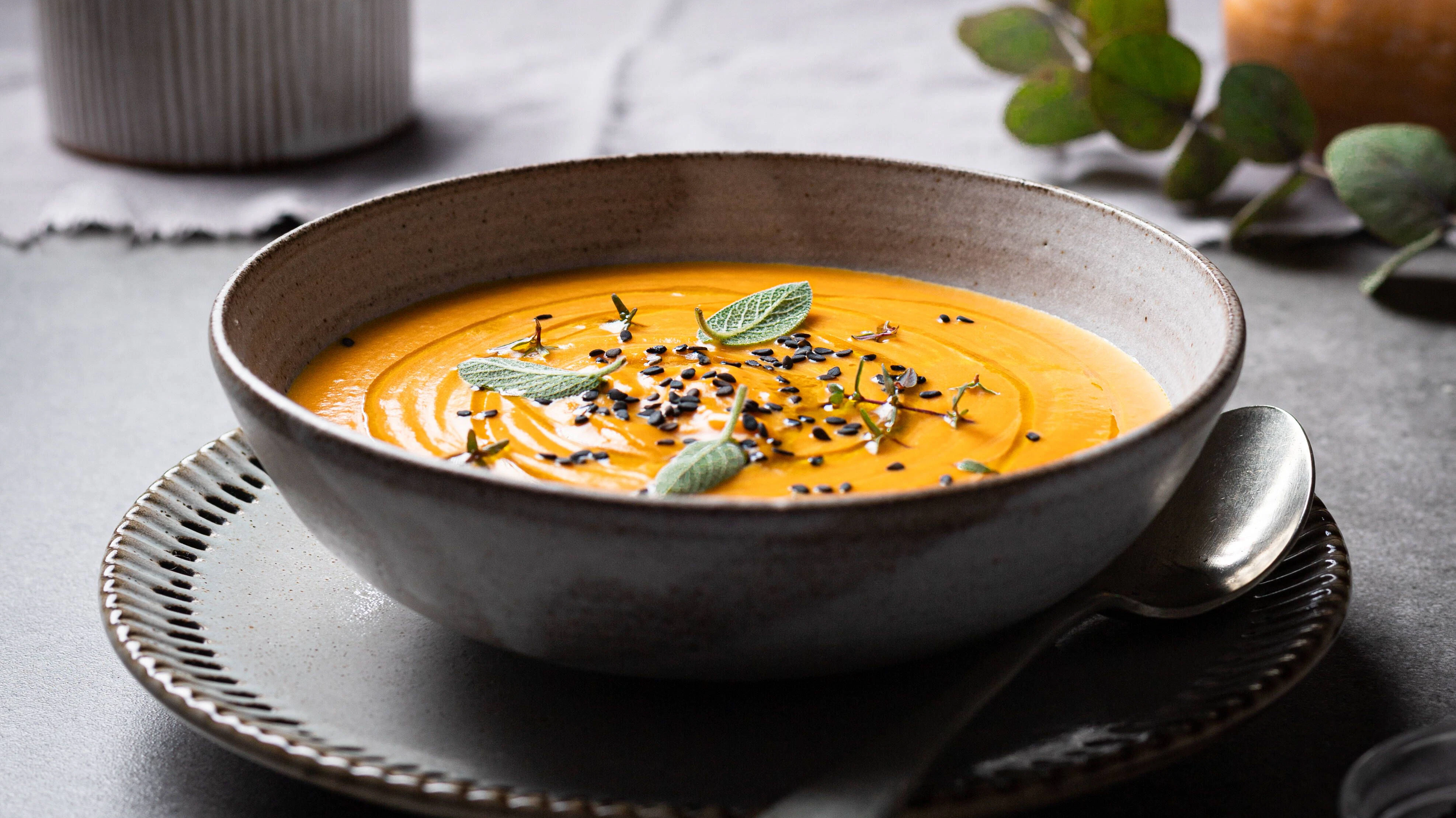 Ein paar Kräuter und eine Handvoll Chiasamen dekorieren die Kürbissuppe perfekt. 