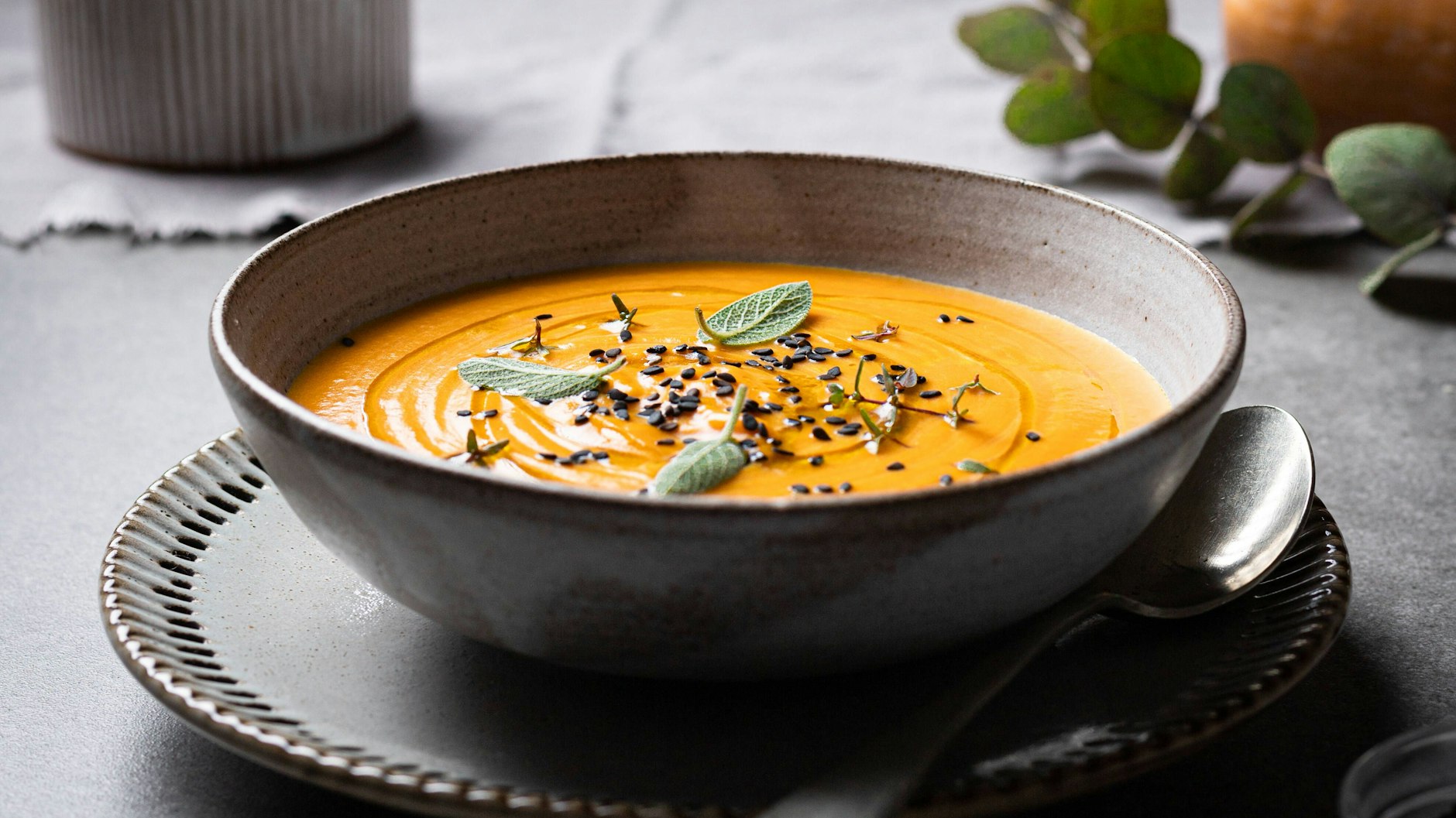 Ein paar Kräuter und eine Handvoll Chiasamen dekorieren die Kürbissuppe perfekt. 