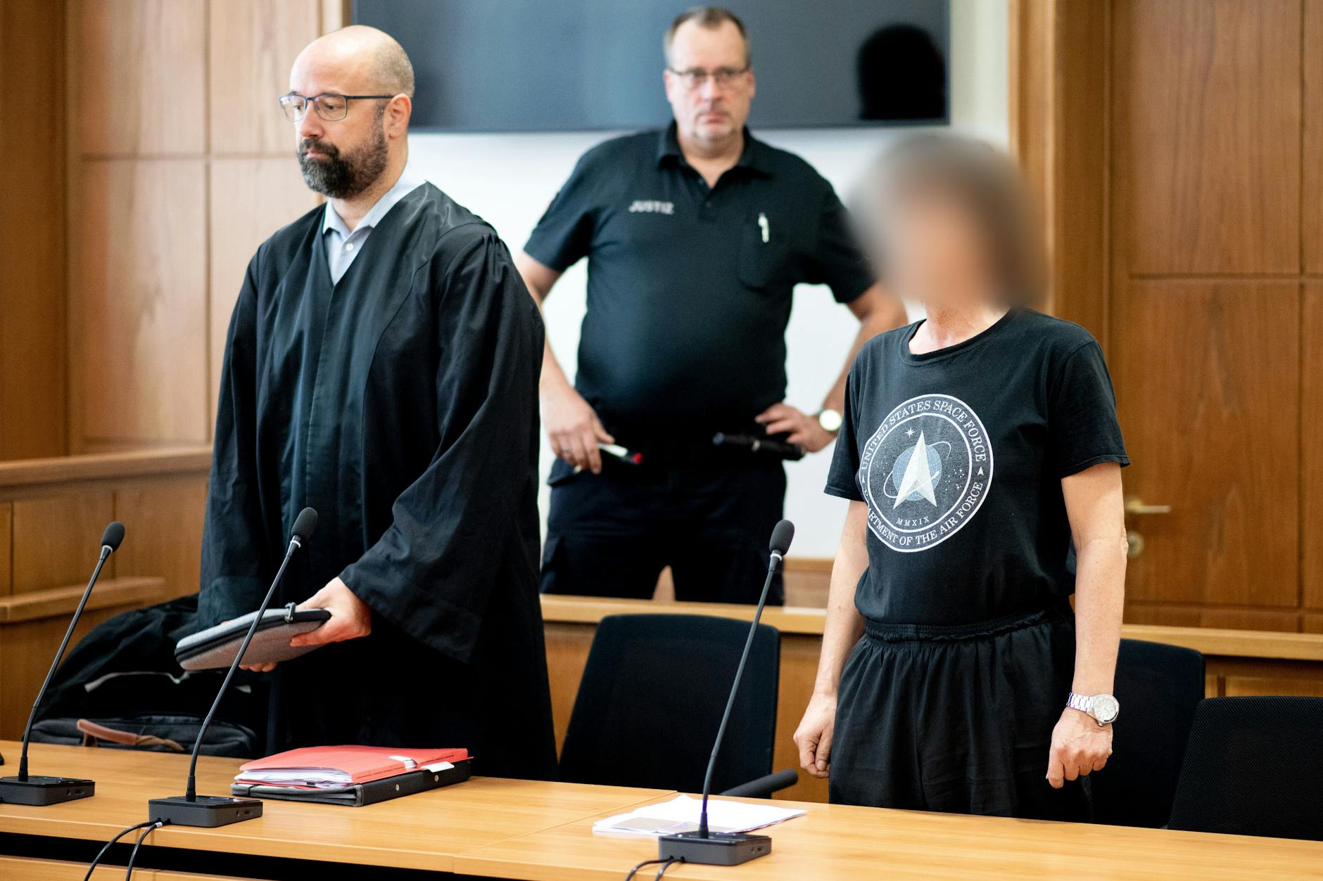 Der Angeklagte Torsten J. (r) steht vor Verhandlungsbeginn neben seinem Anwalt Tobias Pohl (l.) in einem Gerichtssaal. Weil er über Telegram zur Tötung von Menschen aufgerufen haben soll, muss sich der 55-jährige mutmaßliche Reichsbürger vor dem Landgericht Oldenburg verantworten.