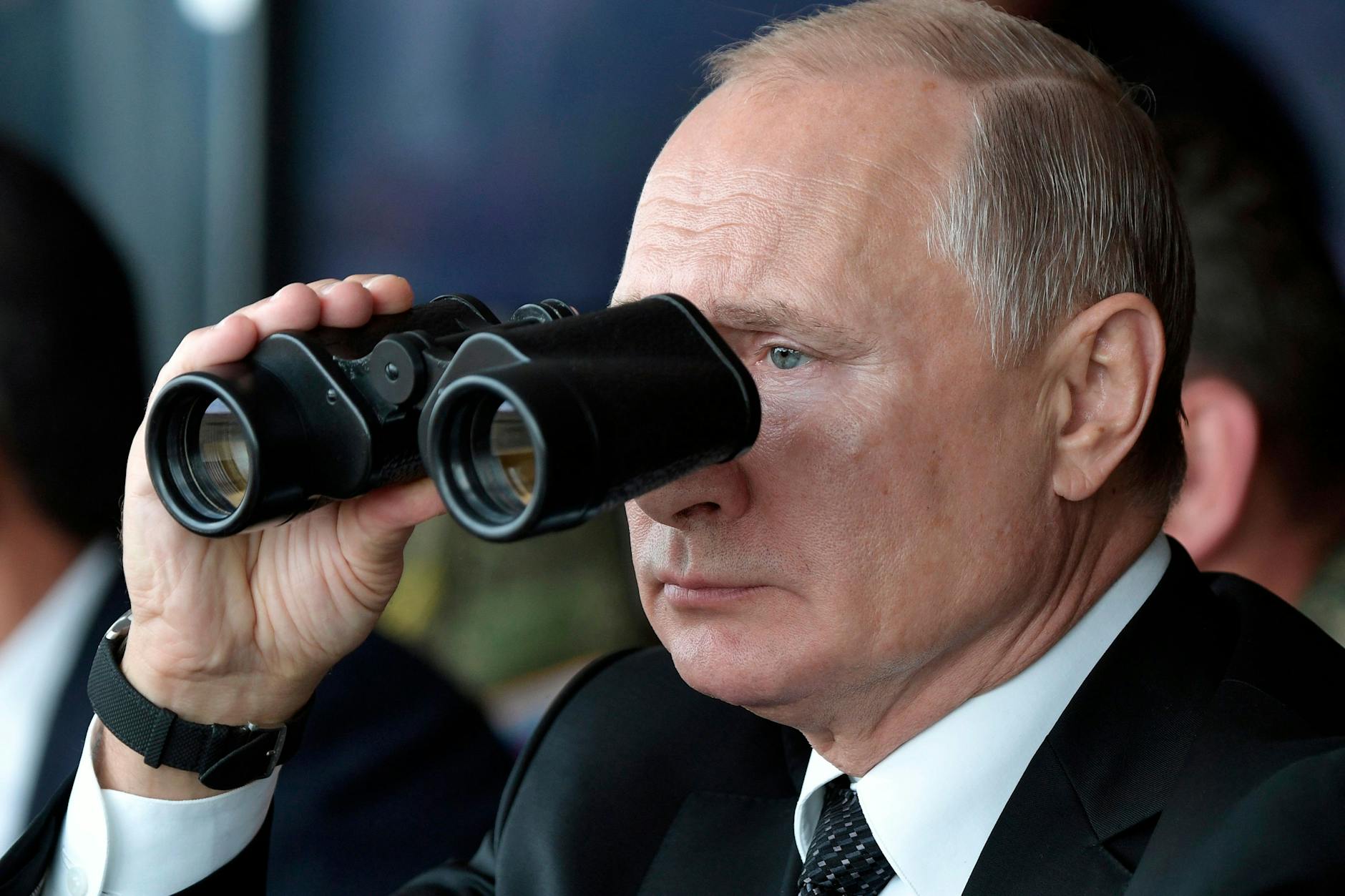 Durch ein Fernglas beobachtet Wladimir Putin, Präsident von Russland, eine Militärübung.
