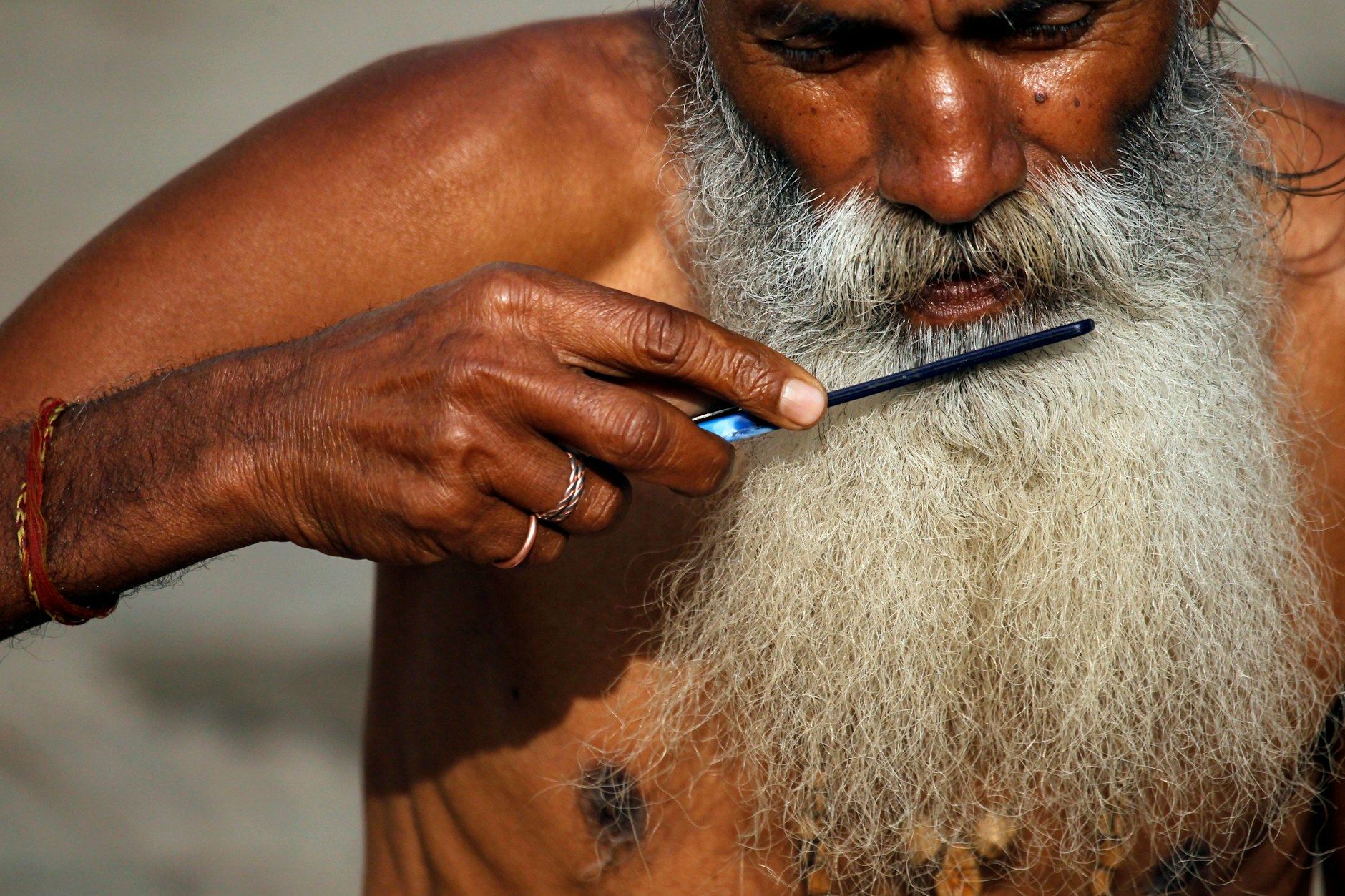 Ein strenggläubiger Hindu, ein „Sadhu“ (Heiliger Mann), kämmt sich im Tempel Pashupatinath in Nepal seinen Bart.