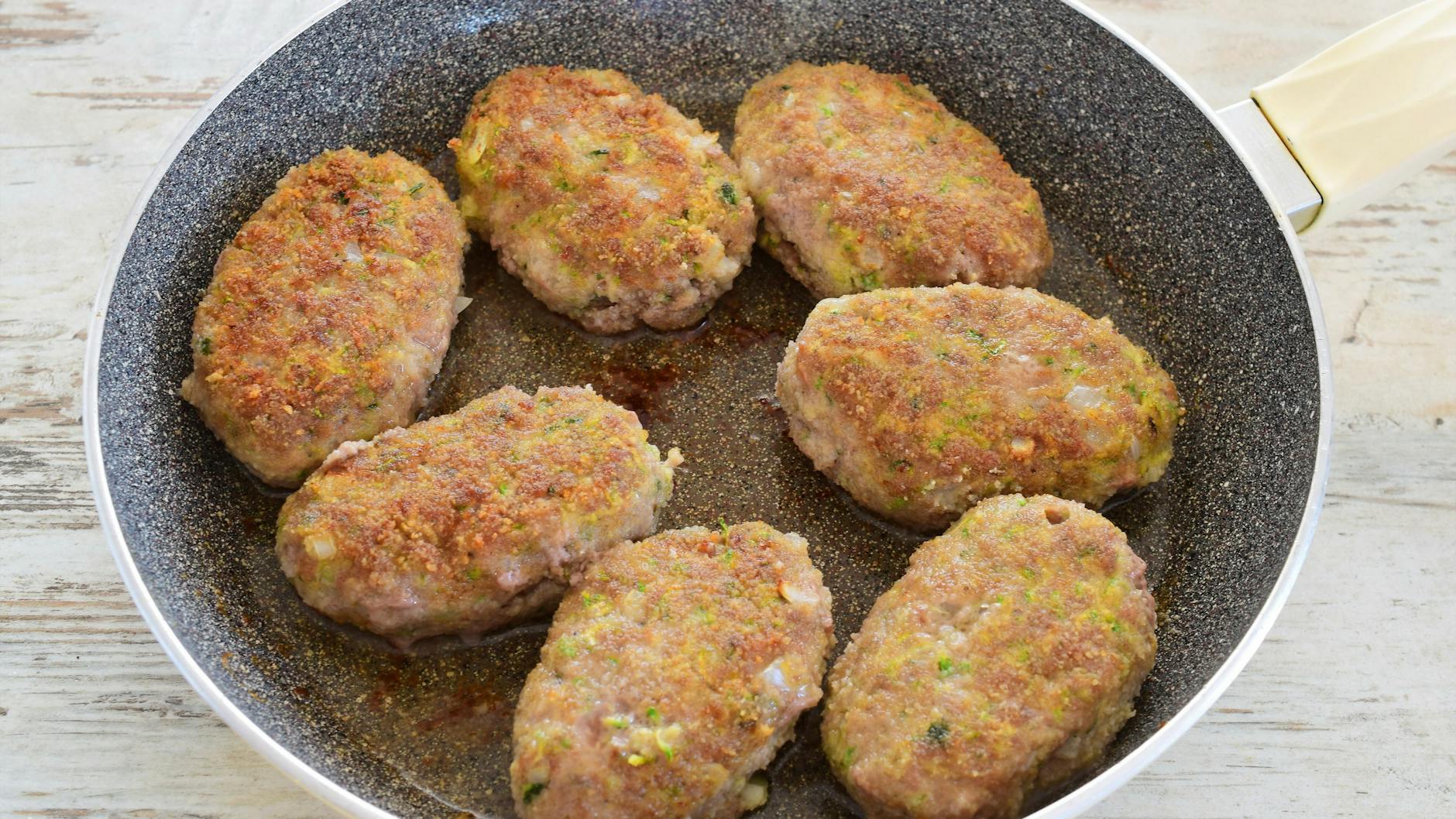 Die Frikadellen mit Zucchini werden erst kurz in der Pfanne angebraten und kommen dann in den Ofen. Bei unserem Rezept sind sie nicht paniert.