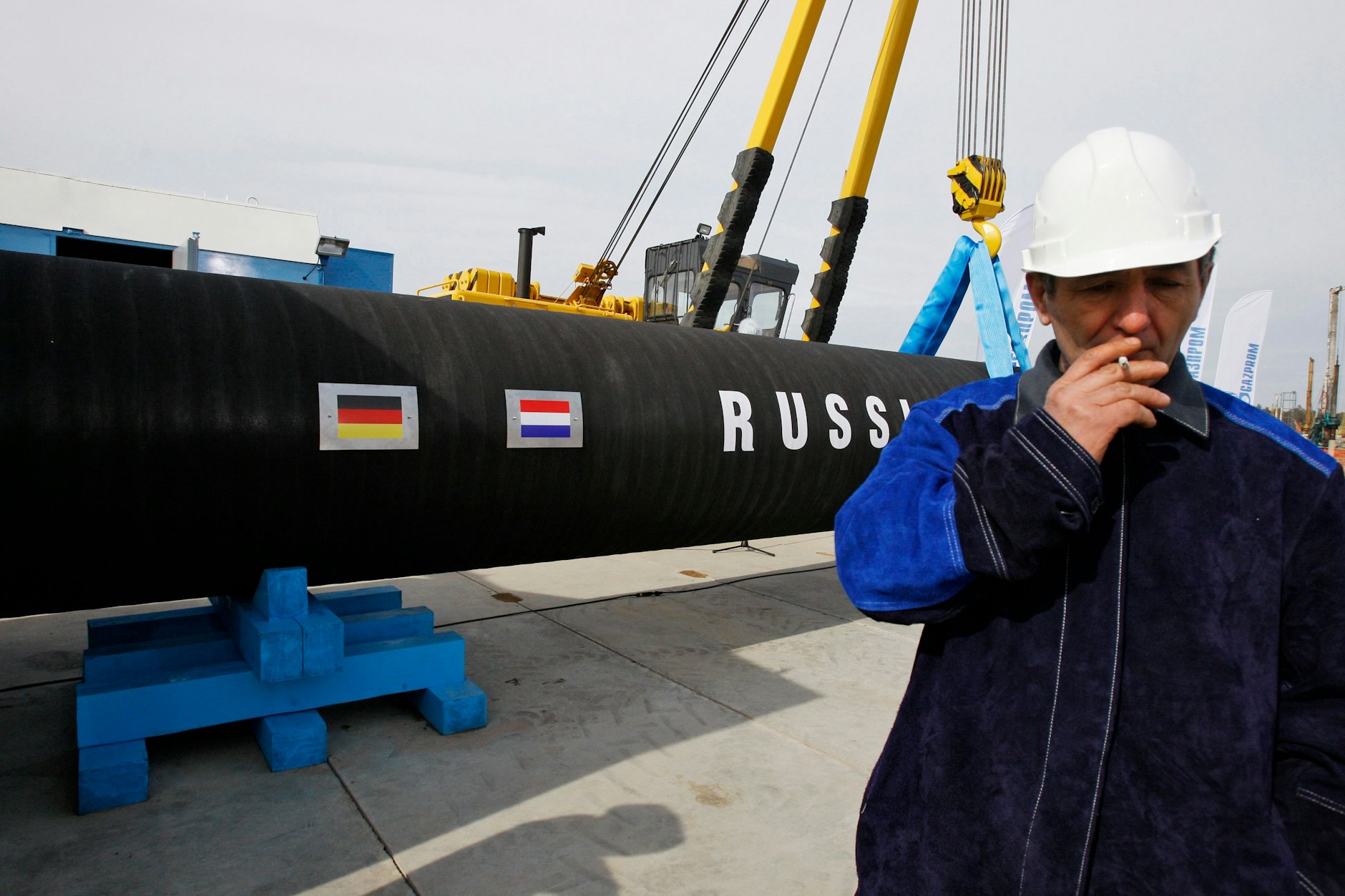 Ein russischer Arbeiter raucht unmittelbar an der Gas-Pipeline Nord Stream 1 an der Stelle, die angeblich undicht sein soll.
