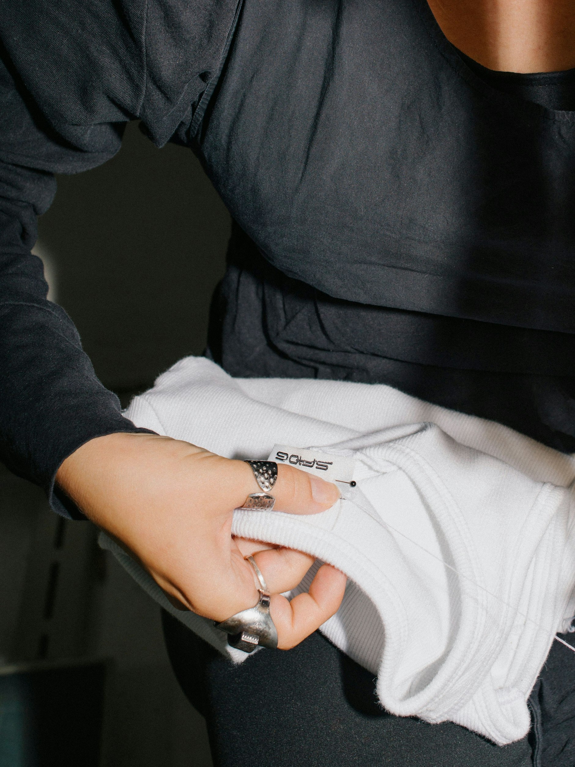 Praktikantin Charlotte Lockton näht die nicht unwichtigen Labels ein.