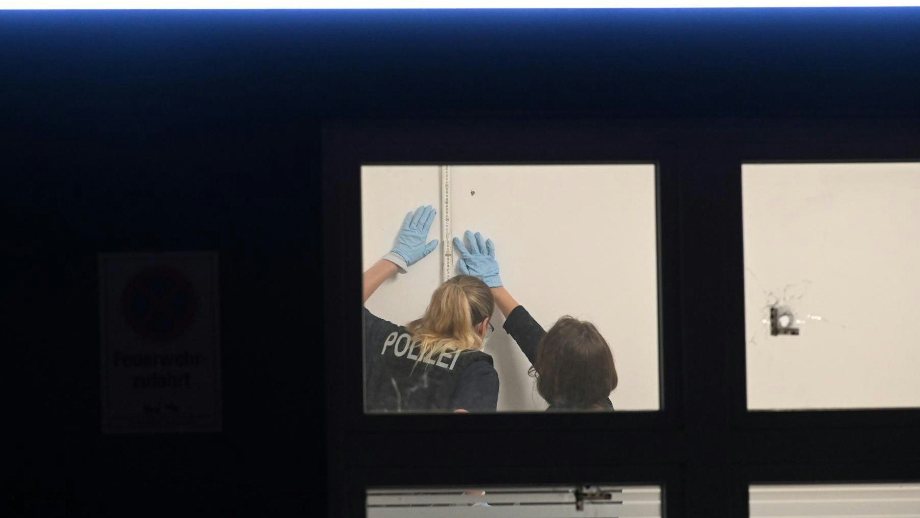 Spurensuche der Polizei: Kugeln durchschlugen die Fenster eines Büros und blieben in der Wand stecken.