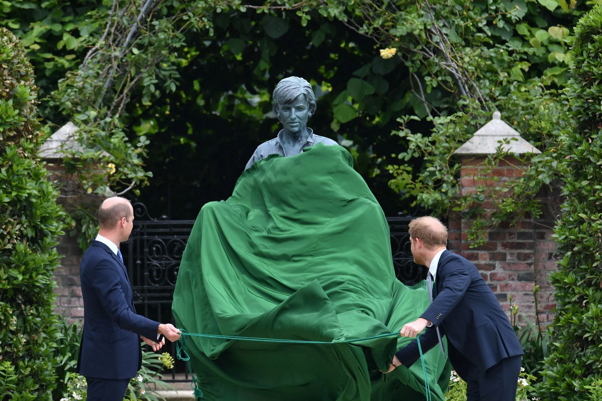 ARCHIV - Die britischen Prinzen William (l) und Harry enthüllen 2021 eine Statue ihrer Mutter Diana im versunkenen Garten des Kensington Palastes.  