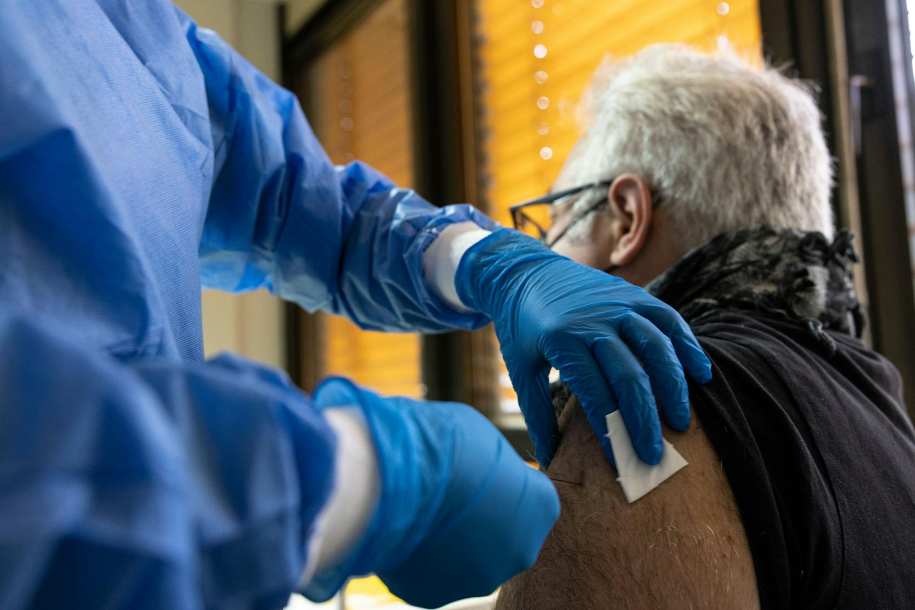 In einem Impfzentrum erhält ein älterer Mann eine Spritze mit einem Corona-Impfstoff. (Archivbild)