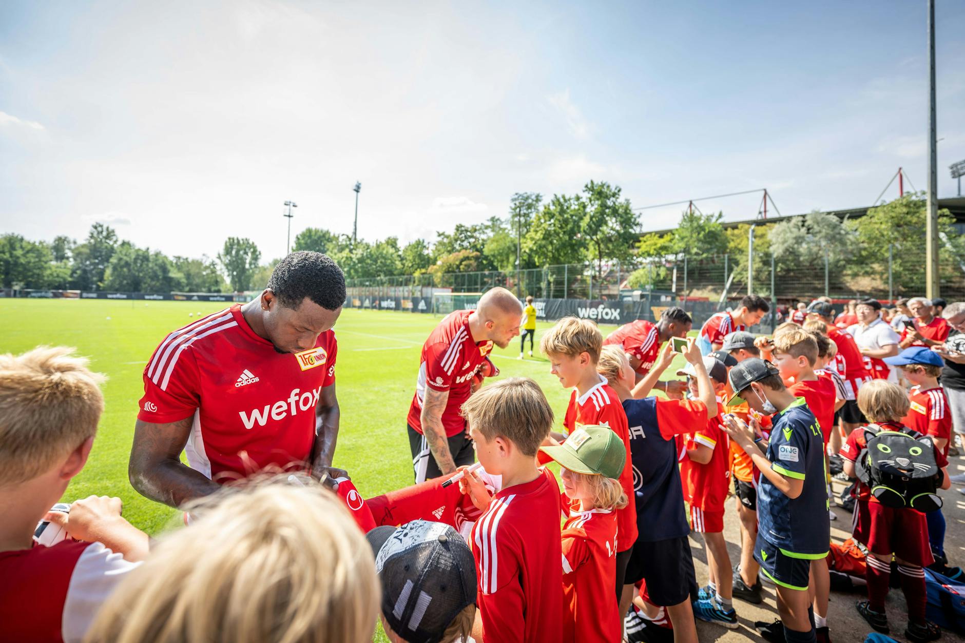 Die Spieler des 1. FC Union Berlin geben nach einer öffentlichen Trainingseinheit fleißig Autogramme.
