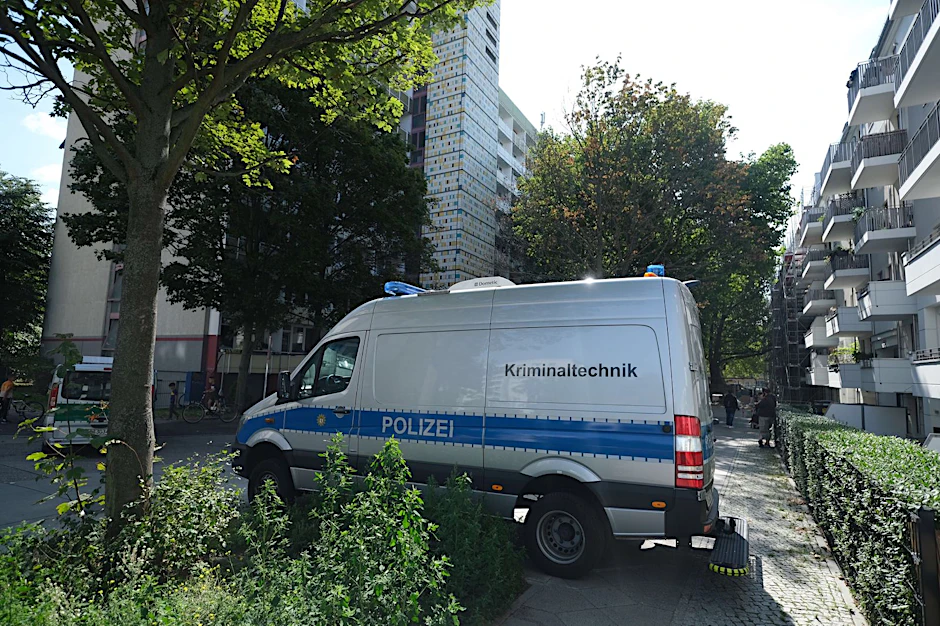 Ein Einsatzwagen der Kriminaltechnik steht vor dem Wohnblock, in dem die Tat passierte.&nbsp;