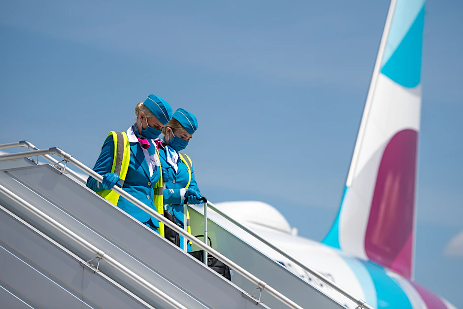 &nbsp;Zwei Flugbegleiterinnen mit Mund-Nasen-Schutz verlassen nach einem Pressetermin ein Flugzeug von Eurowings.