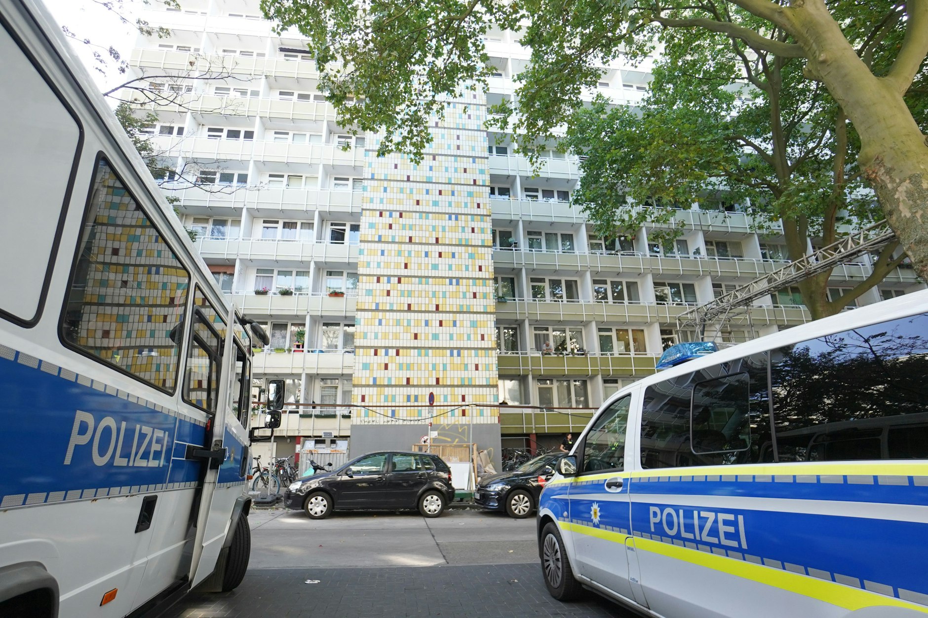 Einsatzfahrzeuge der Polizei stehen vor einem Wohnhaus in der Löwenberger Straße in Berlin-Lichtenberg.