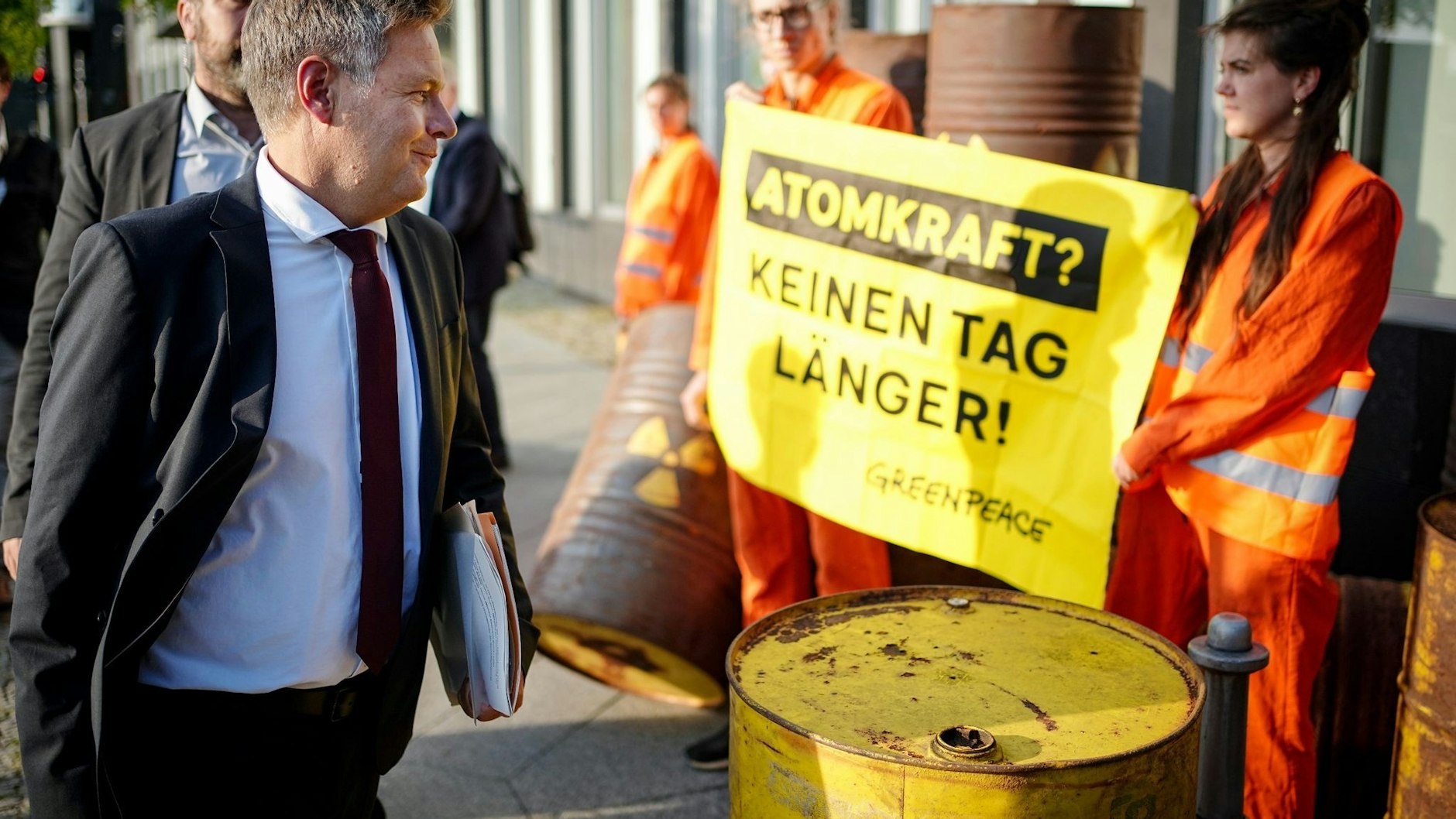Bundeswirtschaftsminister Robert Habeck passiert auf dem Weg zur Pressekonferenz zu den Ergebnissen des Stresstests mehrere Greenpeace-Protestler.&nbsp;