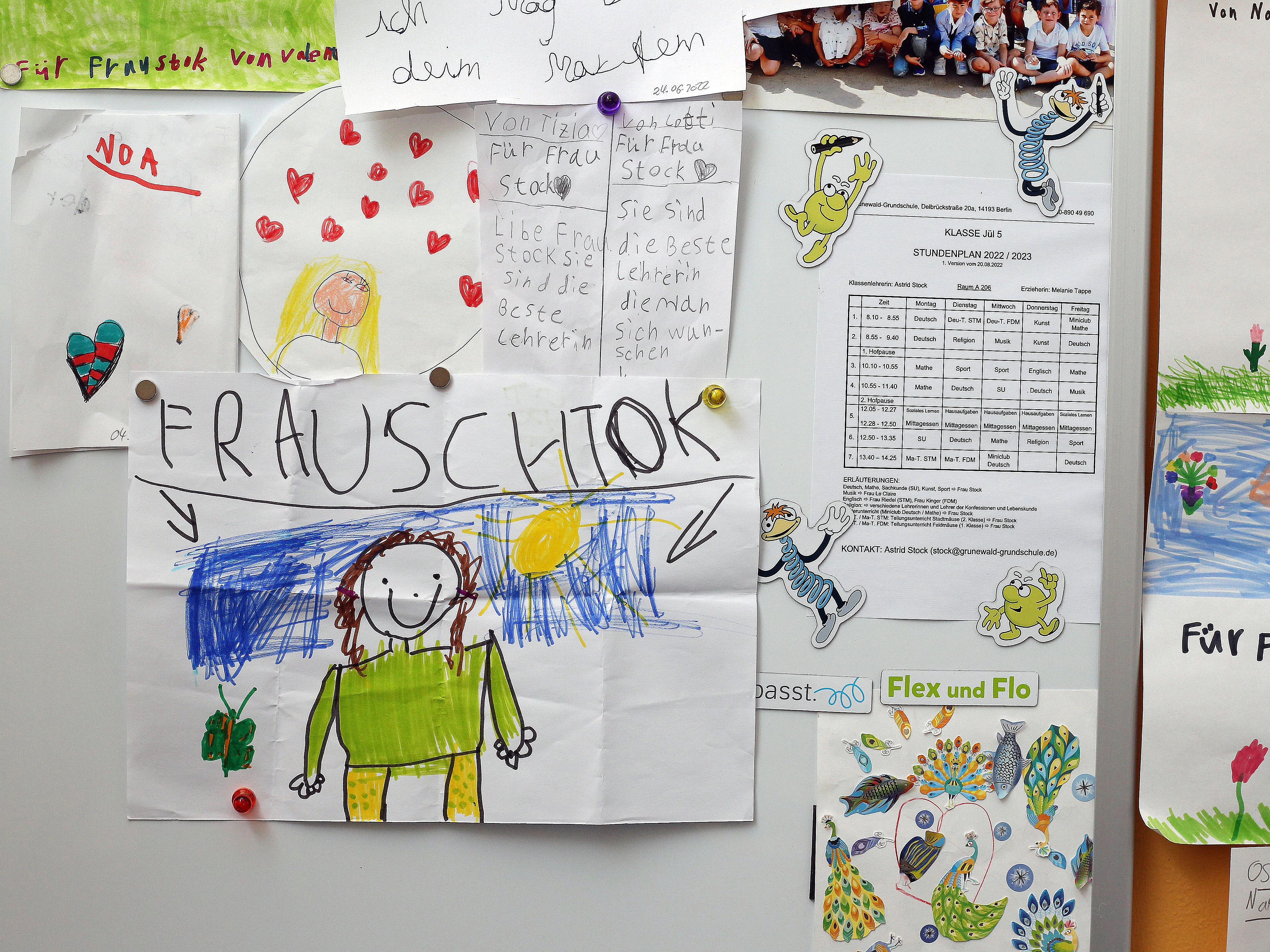 Kinder haben Bilder von ihrer Lehrerin gemalt. Auf dem einen Bild hat das mit der Schreibung des Namens fast schon hingehauen.
