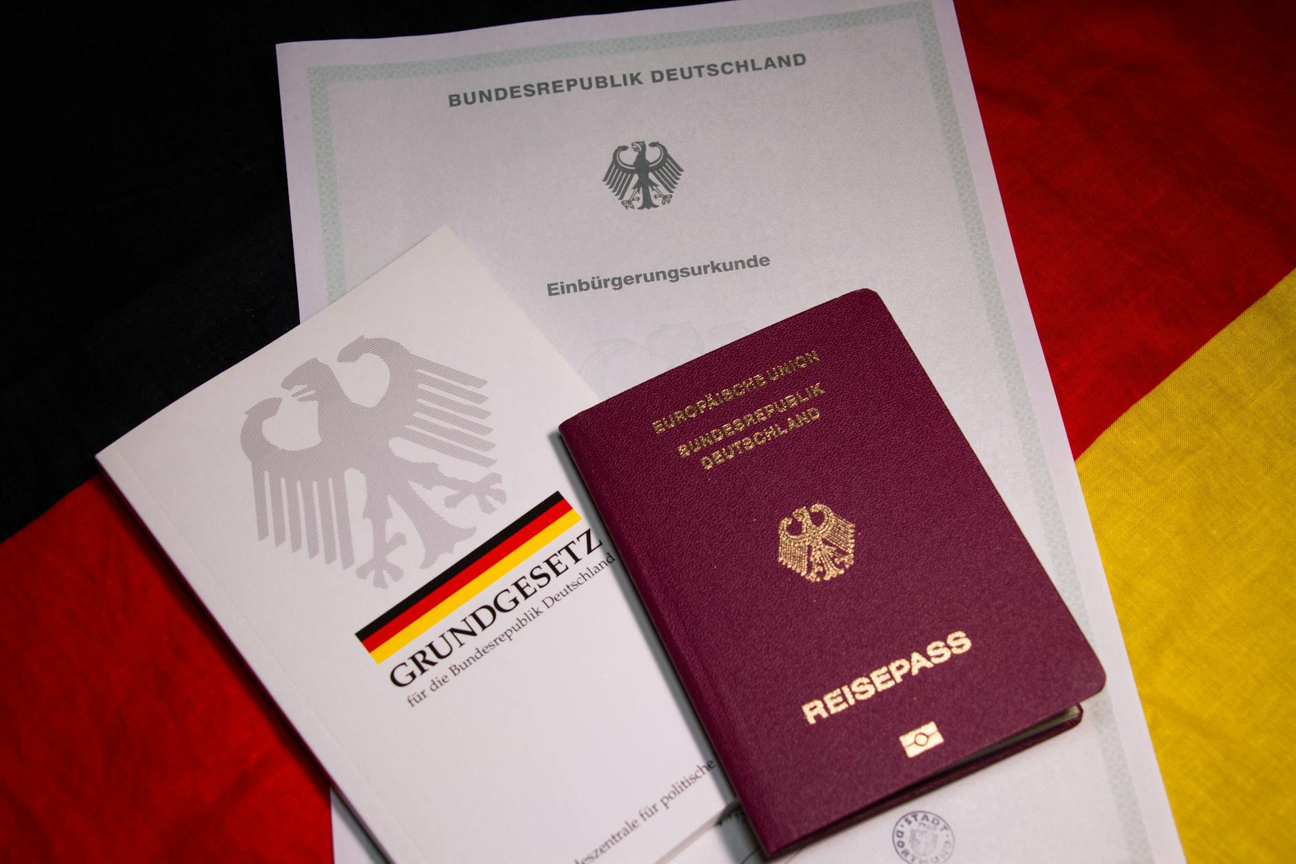 Eine Einbürgerungsurkunde und ein deutscher Reisepass (Symbolbild) 