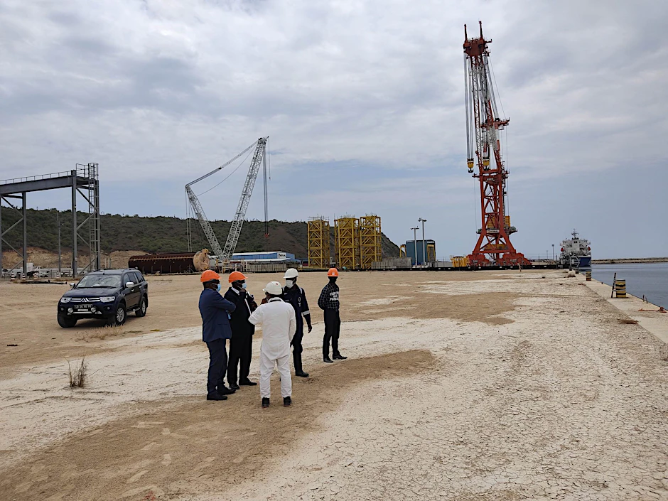 HANDOUT - Bauarbeiter stehen auf dem Gelände des Hafens Barra do Dande, der derzeit im Bau befindlich ist. Auf der Fläche dieses Hafens soll auch eine Elektrolyseanlage durch die deutschen Firmen Gauff und Conjuncta in Kooperation mit Sonangol, größter Ölkonzern Afrikas, gebaut werden.  