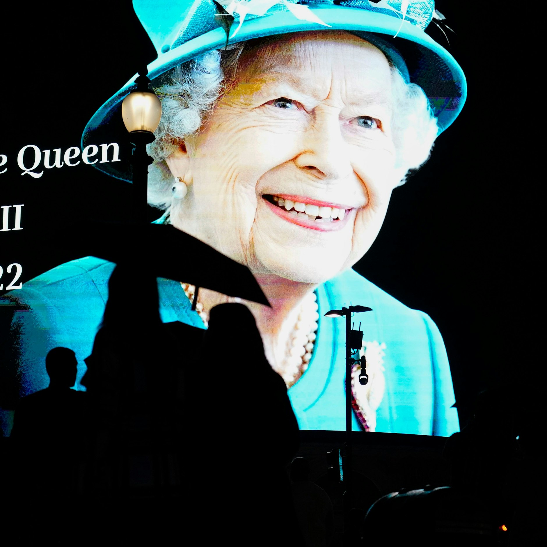 In London gehen Menschen an einem Bild von Königin Elizabeth II. vorbei, das nach ihrem Tod auf eine große Leinwand am Piccadilly Circus projiziert wird. 