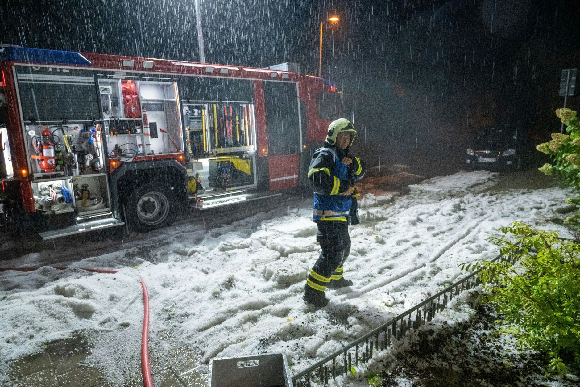 Ein Feuerwehrmann in Stralsund kämpft gegen Hagel und Regen. 