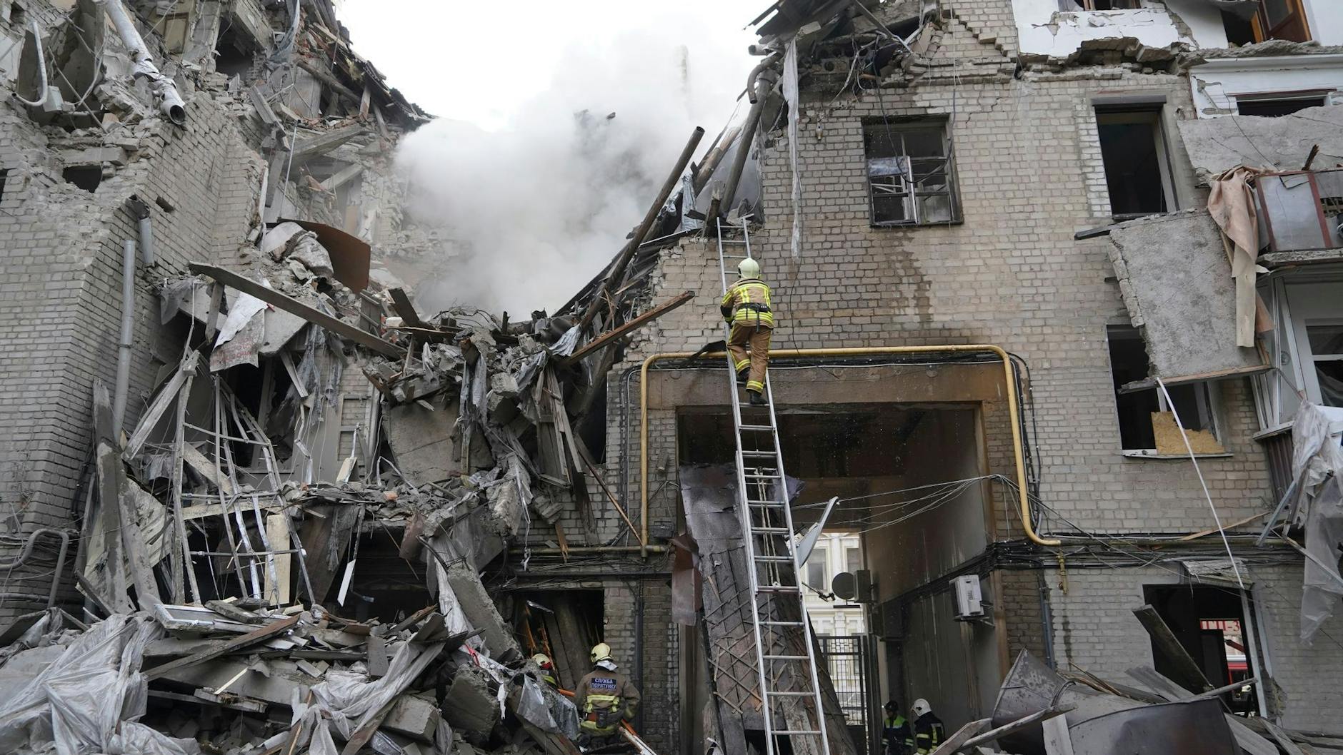 Rettungskräfte arbeiten an einem zerstörten Gebäude in Charkiw.