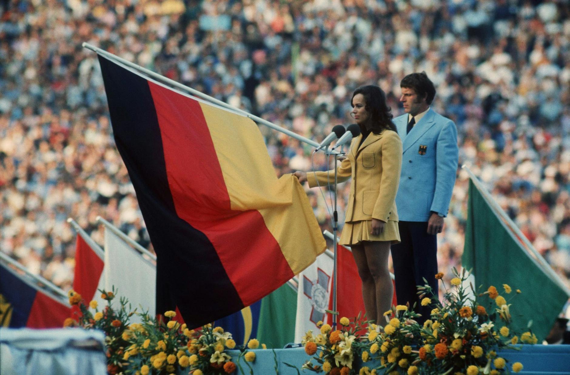 ARCHIV - Fünfkämpferin Heidi Schüller spricht für die im Stadion versammelten Sportler den Olympischen Eid. Hinter ihr der Fahnenträger der deutschen Mannschaft Detlef Lewe.