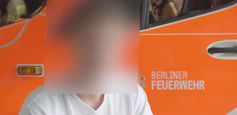 Florian F. in dem Video vor einem Einsatzwagen der Feuerwehr Berlin.