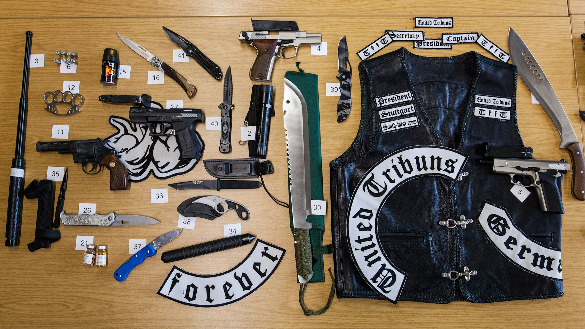 Zahlreiche beschlagnahmte Waffen und eine Lederweste liegen auf einem Tisch im Polizeipräsidium. Die Gegenstände hatte die Polizei bei vier Wohnungsdurchsuchungen von mutmaßlichen Angehörigen der rockerähnlichen Gruppierung „United Tribuns“ in Stuttgart und Umgebung sichergestellt.