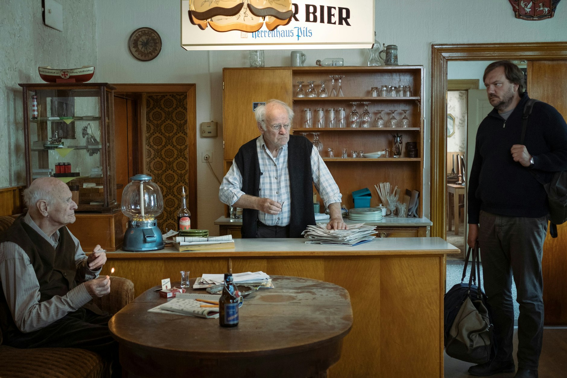 „Mittagsstunde“: Dr. Ingwer Feddersen (Charly Hübner, r.) kommt in die Kneipe des alten Sönke (Peter Franke), wo er aufgewachsen ist. Ein Stammgast ist da: Paule Bahnsen (Dieter Schaad, l.).