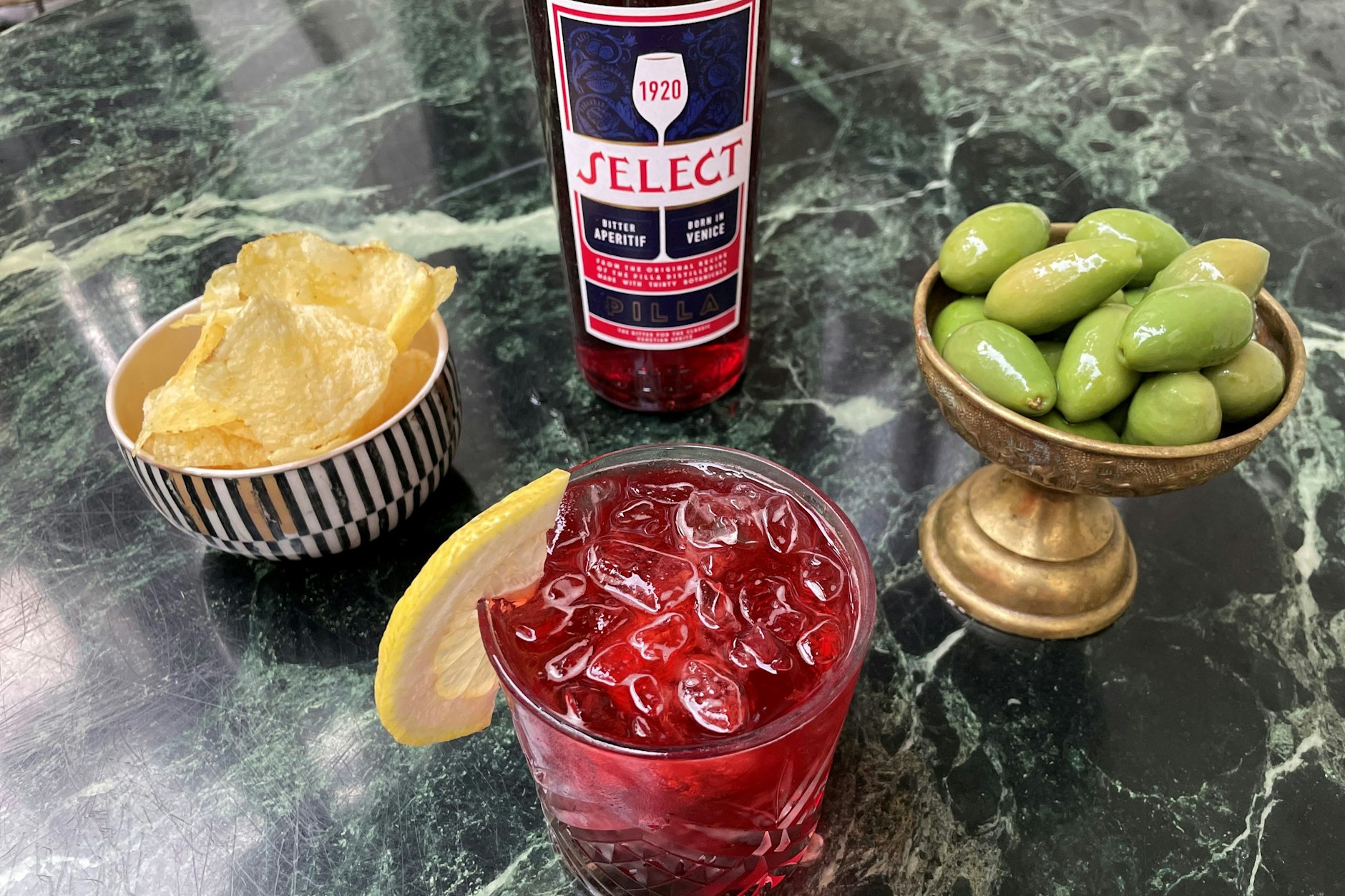 Ein eiskalter Drink, dazu ein paar Kartoffelchips und fleischige, grüne Oliven. So sieht der richtige Feierabend in der Hauptstadt aus.