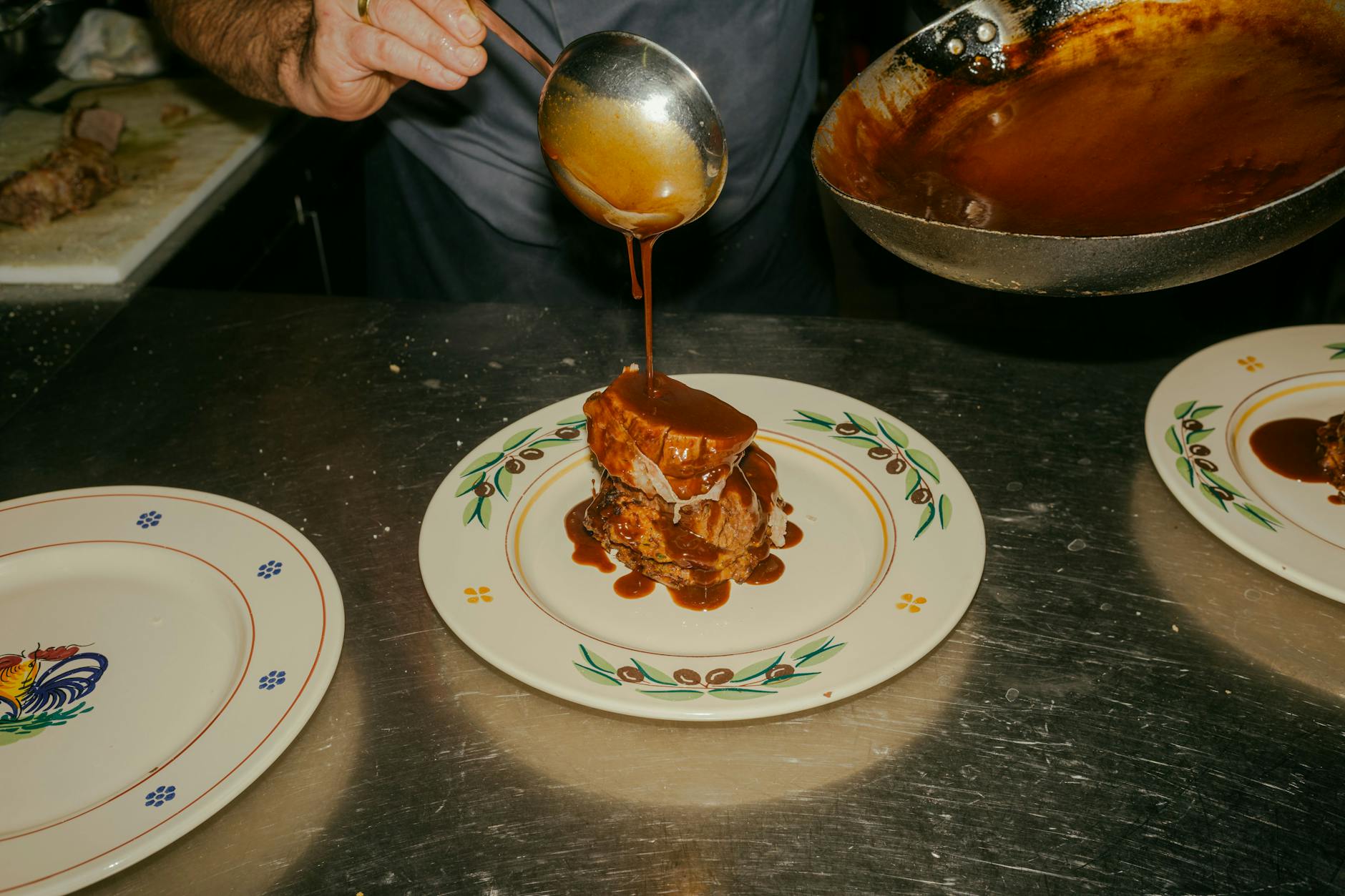 ...angerichtet werden. Die Flesichtranchen werden auf Zucchini-Puffer gesetzt und mit der Soße übergossen.