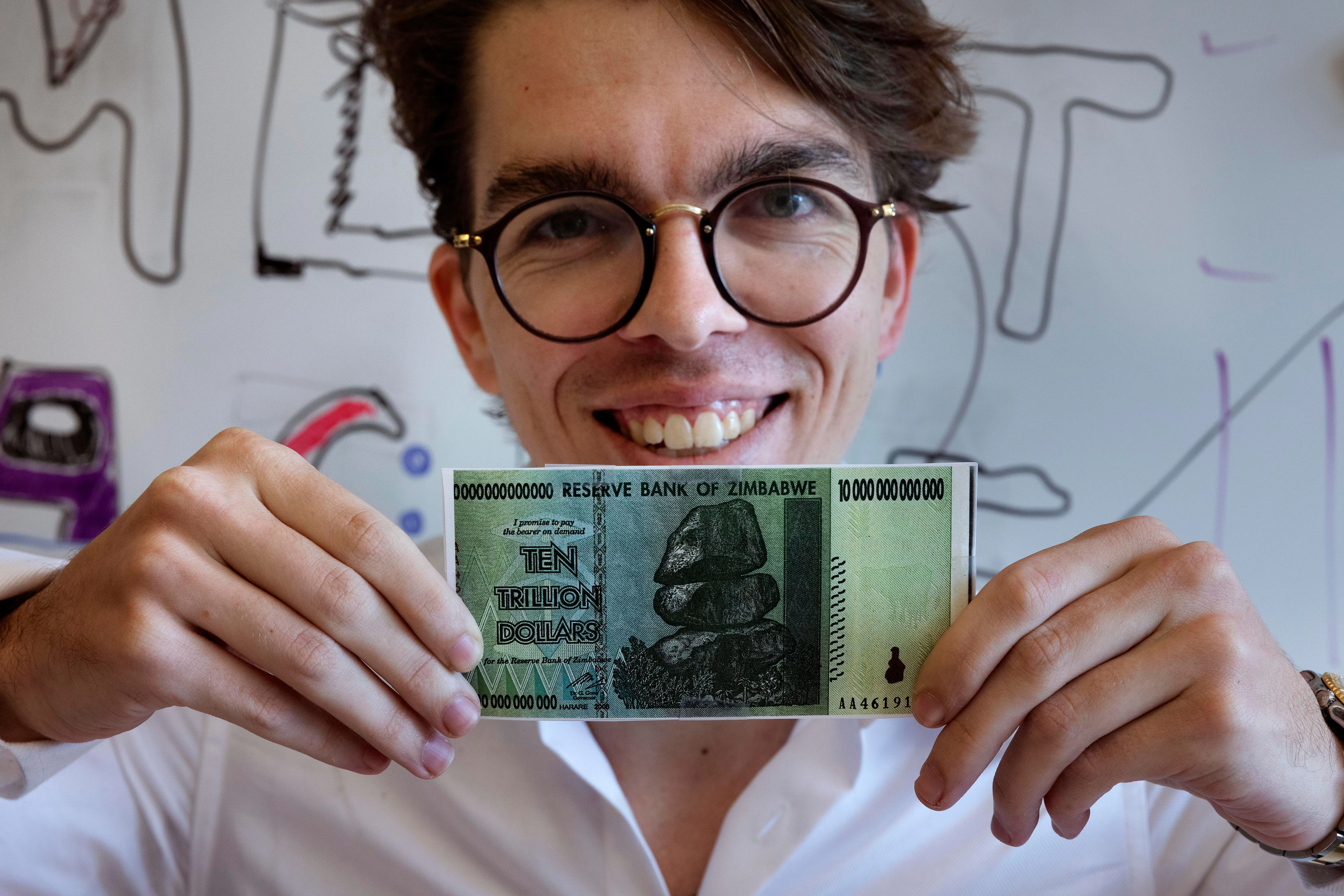 Eric Martinez, Doktorand in der Abteilung für Gehirn- und Kognitionswissenschaften am Massachusetts Institute of Technology, hält einen simbabwischen 10-Billionen-Dollar-Schein in der Hand. Martinez, der auch ein Jurastudium an der Harvard University absolviert hat, teilte sich den Ig-Nobelpreis für Literatur mit Francis Mollica und Edward Gibson für die Analyse der Ursachen, die das Verständnis von Rechtsdokumenten unnötig erschweren.&nbsp;