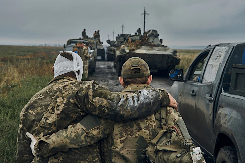 Arm in Arm: Ein ukrainischer Soldat hilft einem verwundeten Kameraden auf der Straße im befreiten Gebiet in der Region Charkiw.