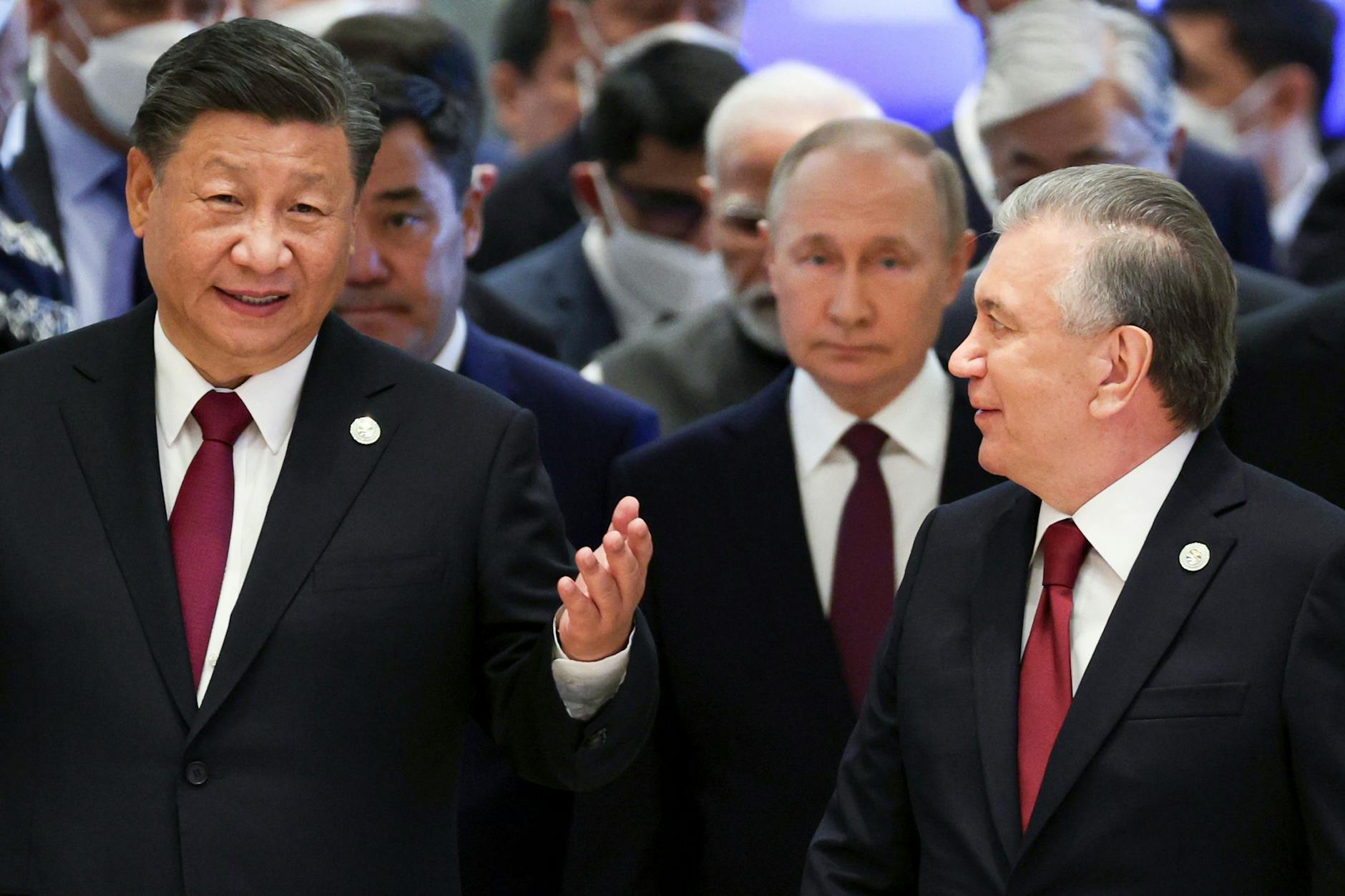 Der chinesische Präsident Xi Jinping spricht mit dem usbekischen Präsidenten Schawkat Mirziyoyev am 16. September beim Gipfel der Shanghaier Organisation für Zusammenarbeit (SOZ) in Samarkand, Usbekistan. Der russische Präsident Wladimir Putin bleibt im Hintergrund.